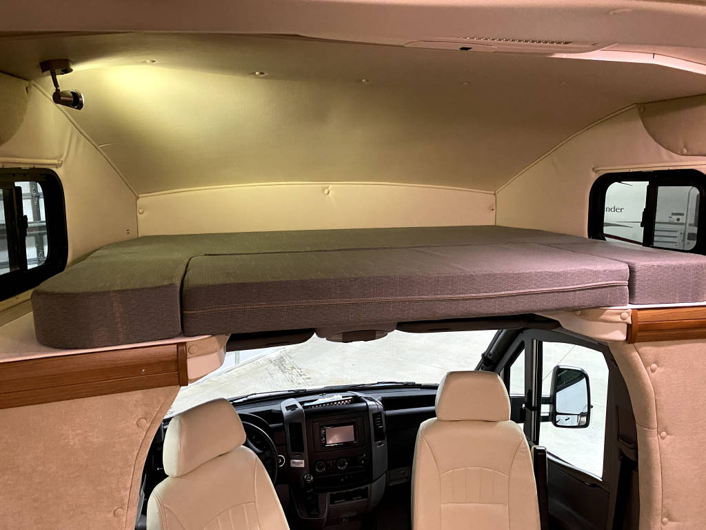 This RV rental interior features an overhead bed above the driver's cab, ideal for a camper's comfortable sleep.. Winnebago View 2014