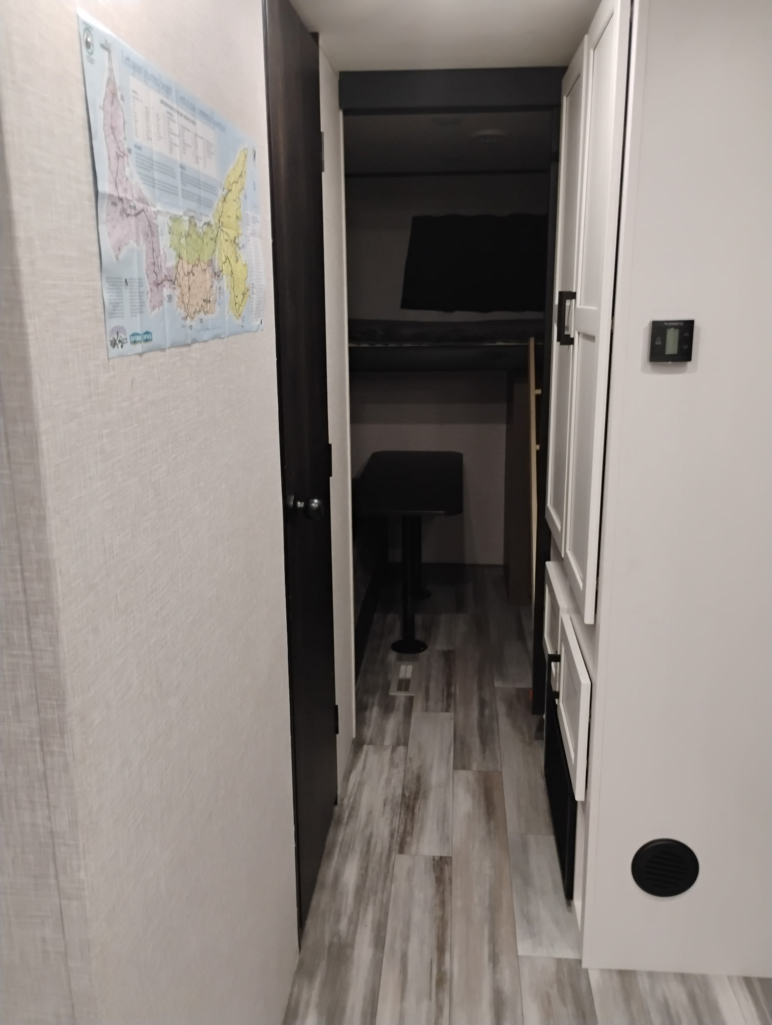 Inside an RV rental: a hallway with a PEI map, bunk beds, and storage for road trip adventures.. Jayco Jay Flight SLX 2024