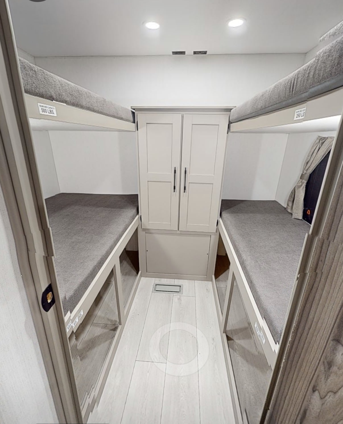 Modern RV rental bunk area with four gray-cushioned beds, a central cabinet, and wood-look flooring.. kz connect 281bhkse 2026