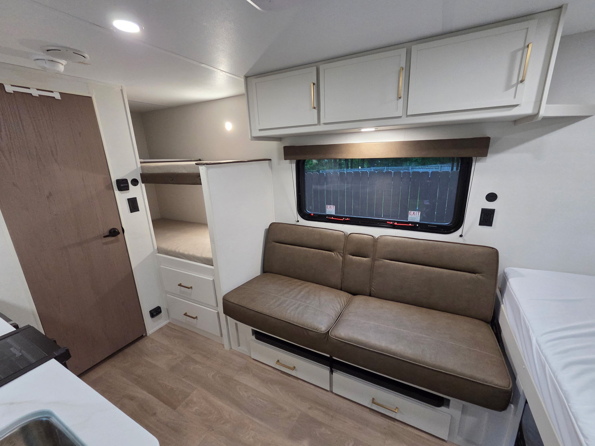 RV rental interior with bunk beds, a cozy sofa, and kitchen area. Modern design perfect for family travel.. Grand Design Transcend One 2026