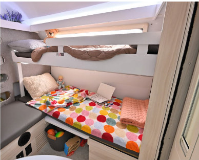 Cozy RV rental bunk beds, fully set up with colorful bedding and toys, ideal for kids on family adventures.. nuCamp T@B 2024