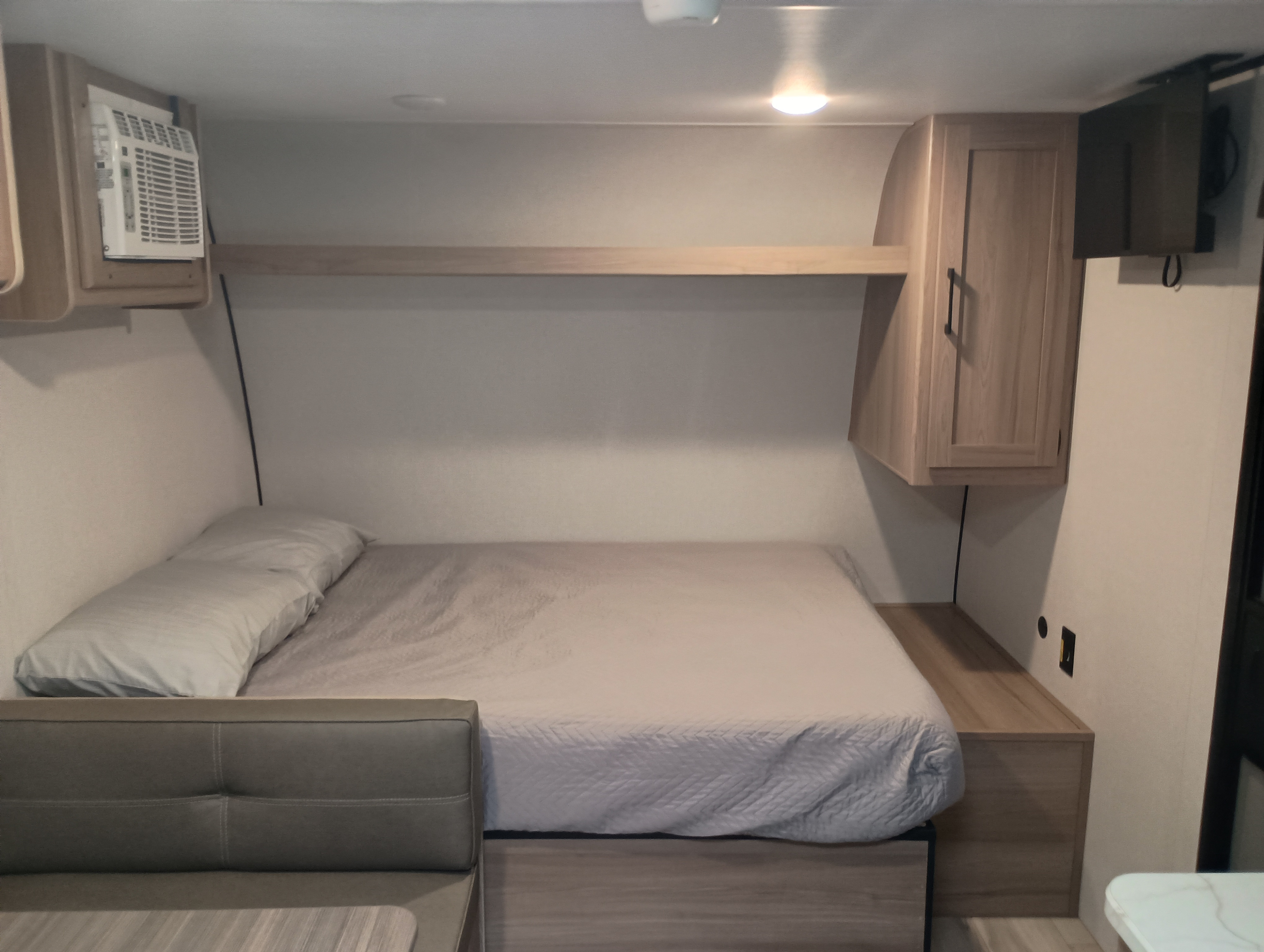 Inside this **rv rental**, find a compact bedroom with a comfortable bed, AC, storage cabinet, shelf, and TV for your travels.. Dutchmen Coleman 2025