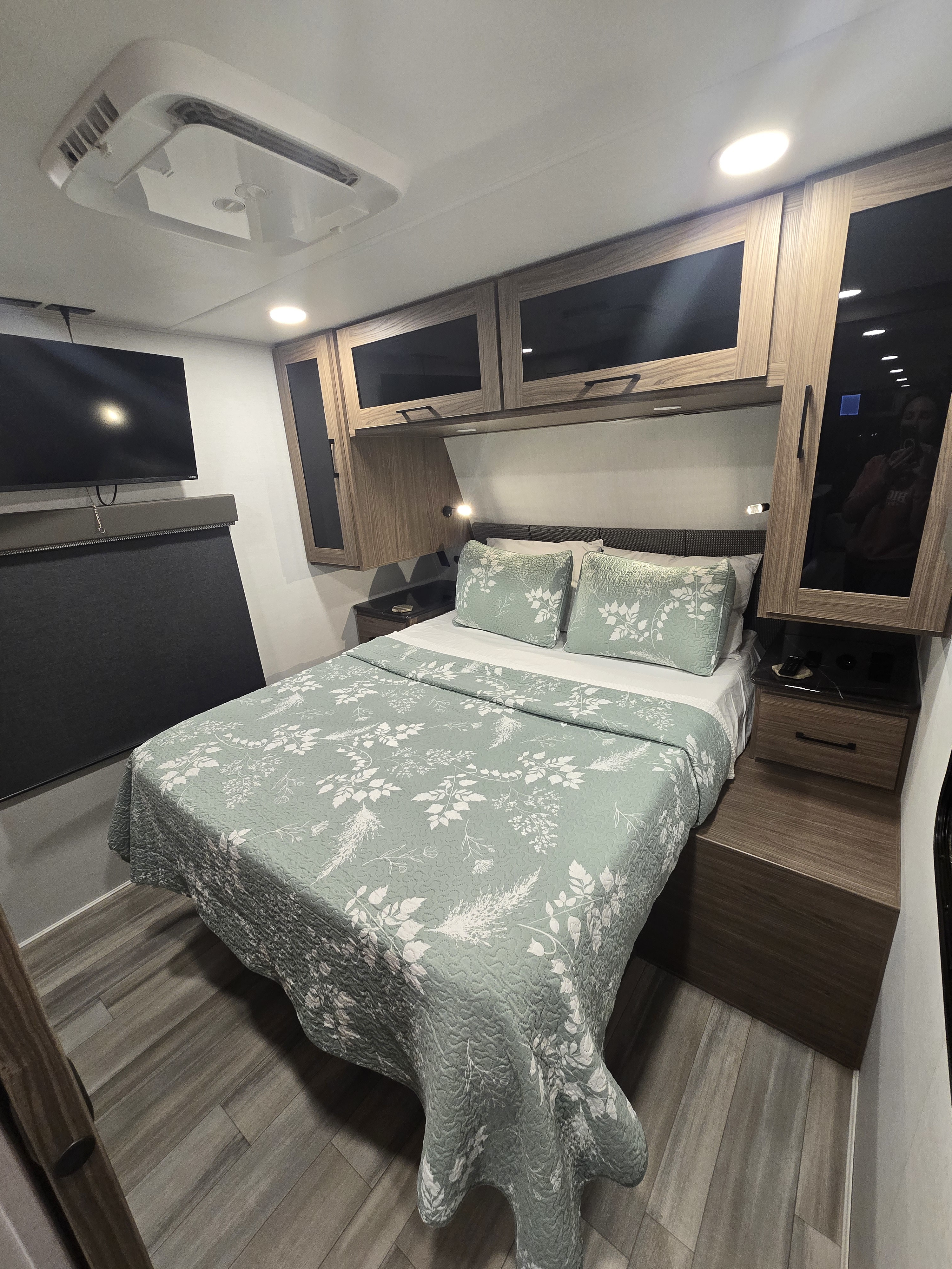 Cozy RV rental bedroom with floral bedding, smart storage, and entertainment for your next adventure.. Alliance Delta 292RL 2025