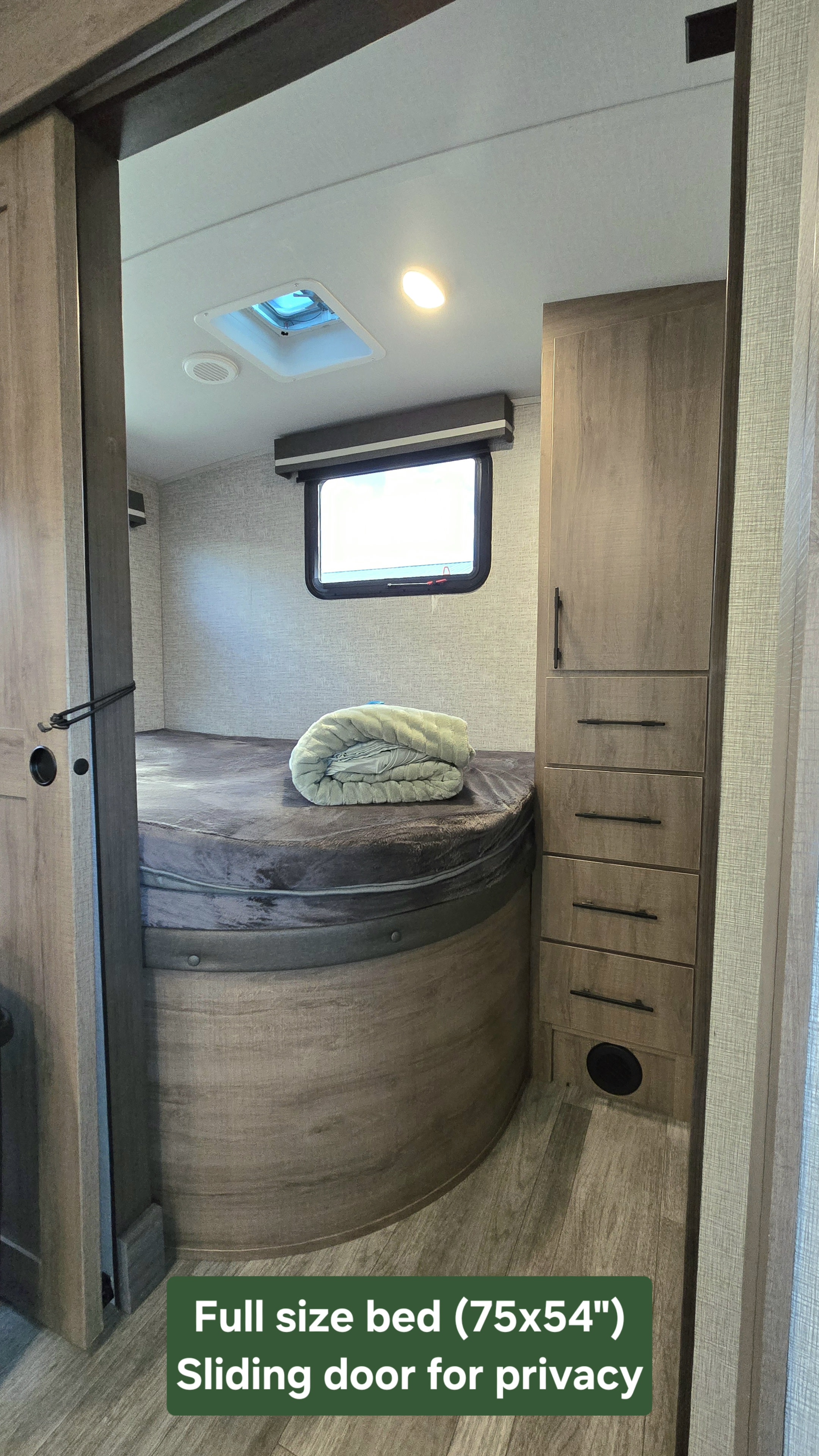 RV rental bedroom: Full-size bed (75x54") with sliding door for privacy and built-in storage.. Grand Design Imagine 2023