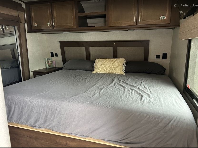 RV rental bedroom interior with a large bed, overhead cabinets, and nightstands. Perfect for travel comfort.. Highland Ridge RV Open Range 2020