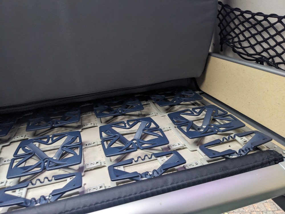 RV rental comfort: Detailed view of a spring-loaded bed slat system under a gray mattress for enhanced sleep.. Mercedes Benz James Cook / Westfalia Westfalia James Cook 2006