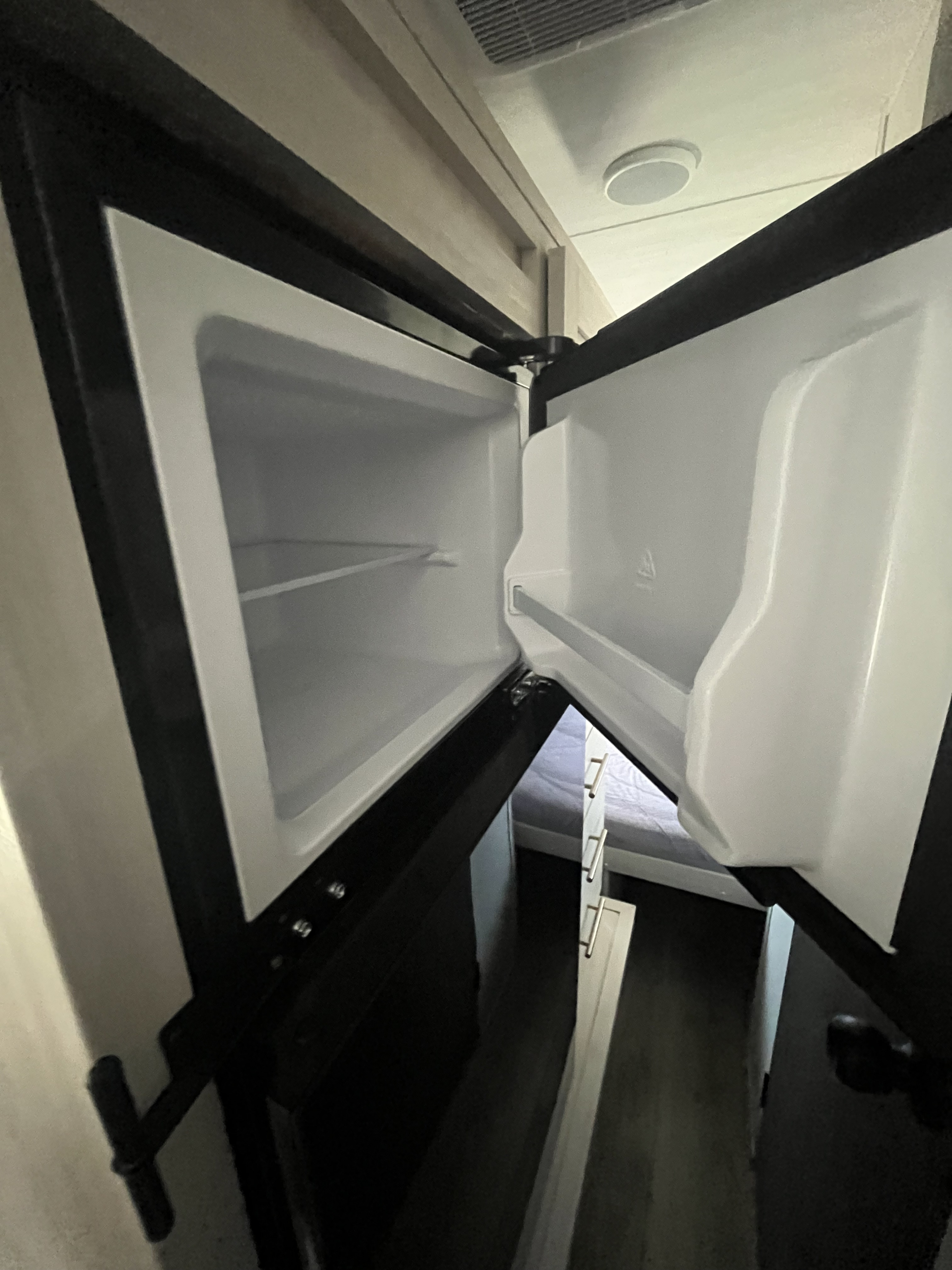 Compact, open refrigerator inside an rv rental, featuring clean shelves and door storage, ready for provisions.. Forest River RP-190 2026