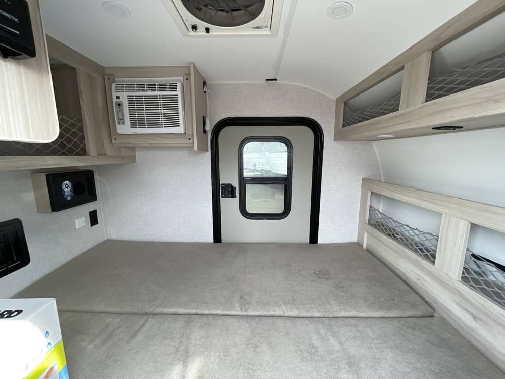 Compact rv rental interior featuring a comfy sleeping area, AC, door, and mesh storage. Ideal for adventurers.. Bontrager Outdoors Bontrager Outdoors Trailer 2026