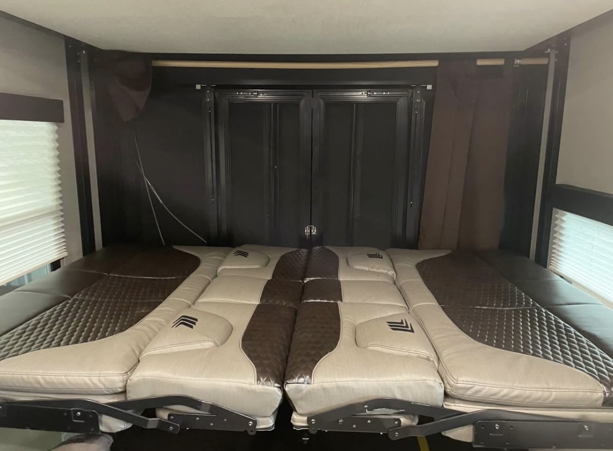This RV rental offers a modular, two-tone bed/seating area, rear cargo door with screens, and window blinds for comfort.. Grand Design Momentum 2021