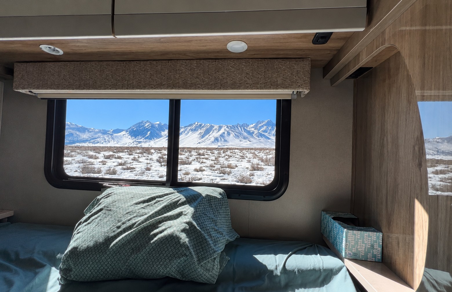 Experience stunning snowy mountain views from a cozy rv rental bedroom. A winter landscape perfect for serene travel.. Entegra Coach Qwest 2021