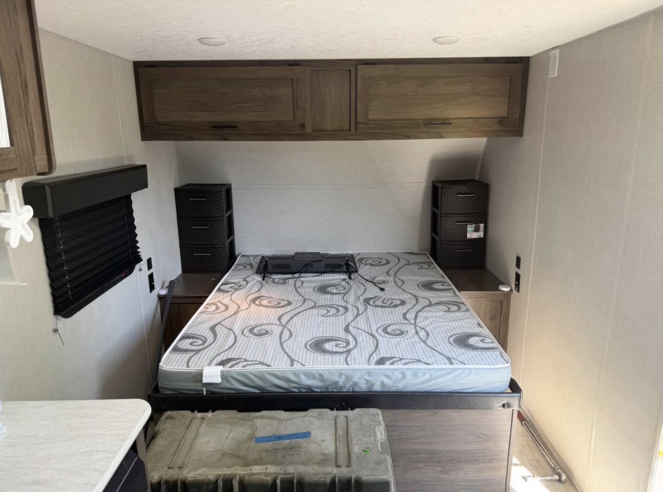 RV rental bedroom with bed, overhead cabinets, and side storage for compact travel accommodation.. Avenger LT 2021