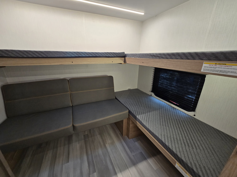 This rv rental features cozy bunk beds and an L-shaped seating area, ideal for comfortable family travel.. Cruiser RV Avenir 2025