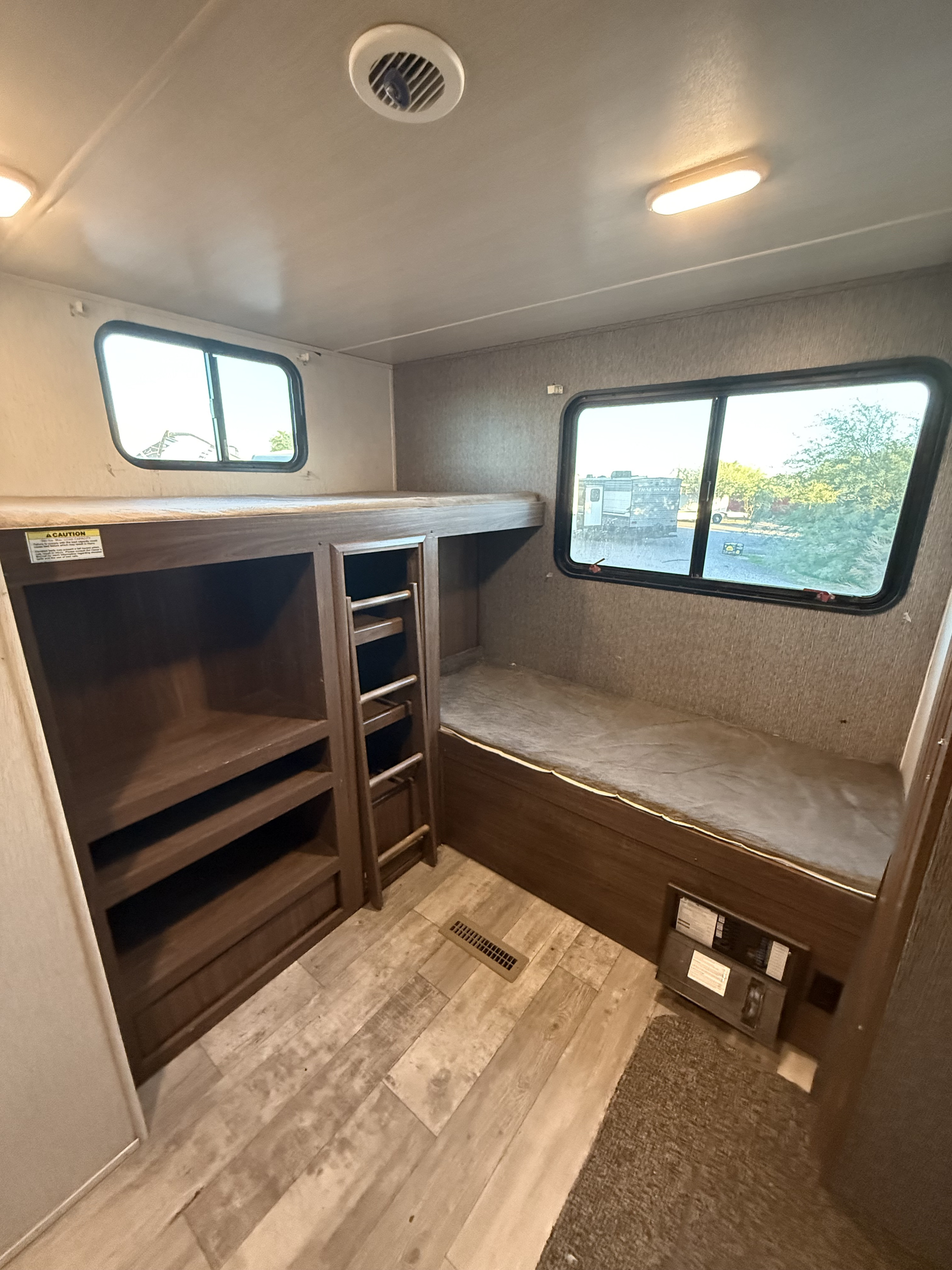 RV rental bunk beds with a ladder, storage, windows, and wood-look flooring, offering cozy sleeping quarters.. Pioneer DS320 2019