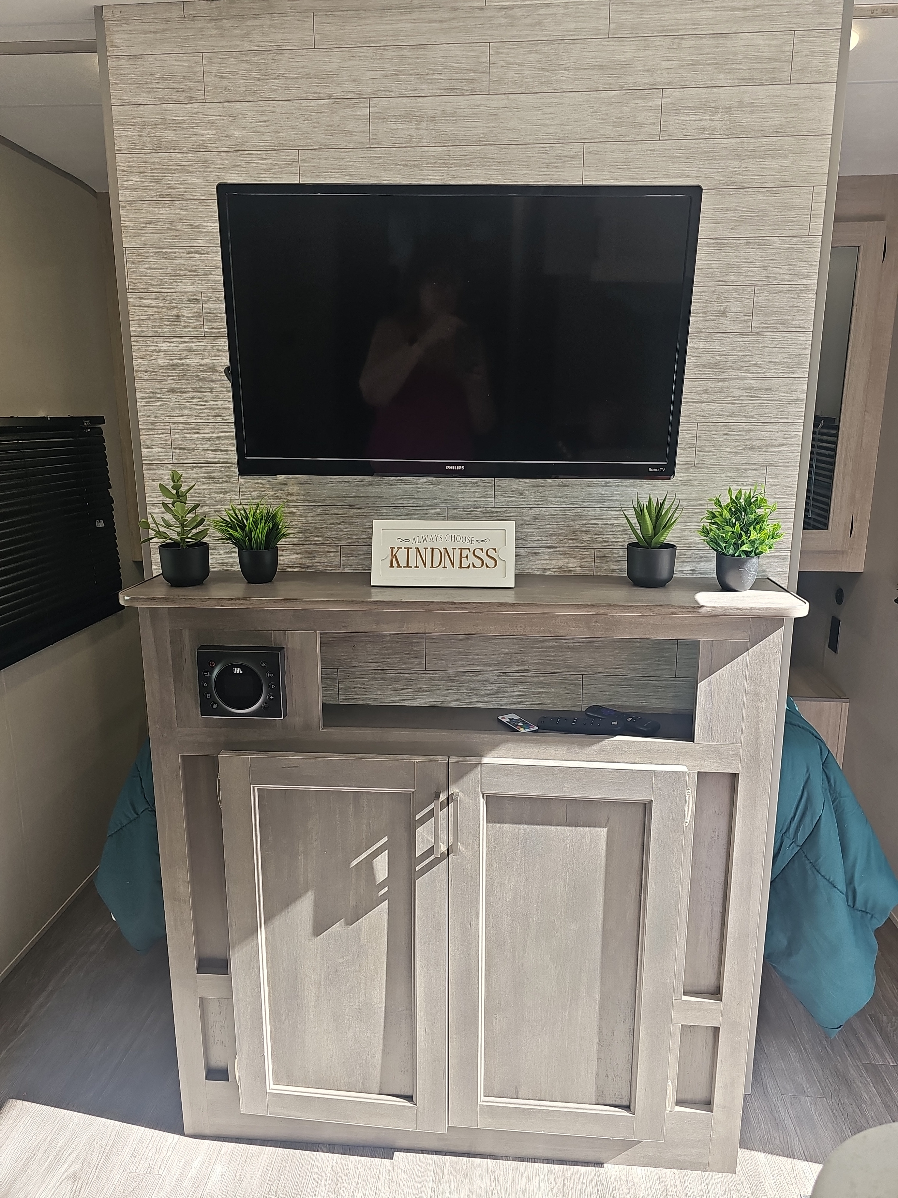 Modern rv rental entertainment center with TV, JBL speaker, and decor. Comfort for your travels.. Forest River Aurora Aurora 2026