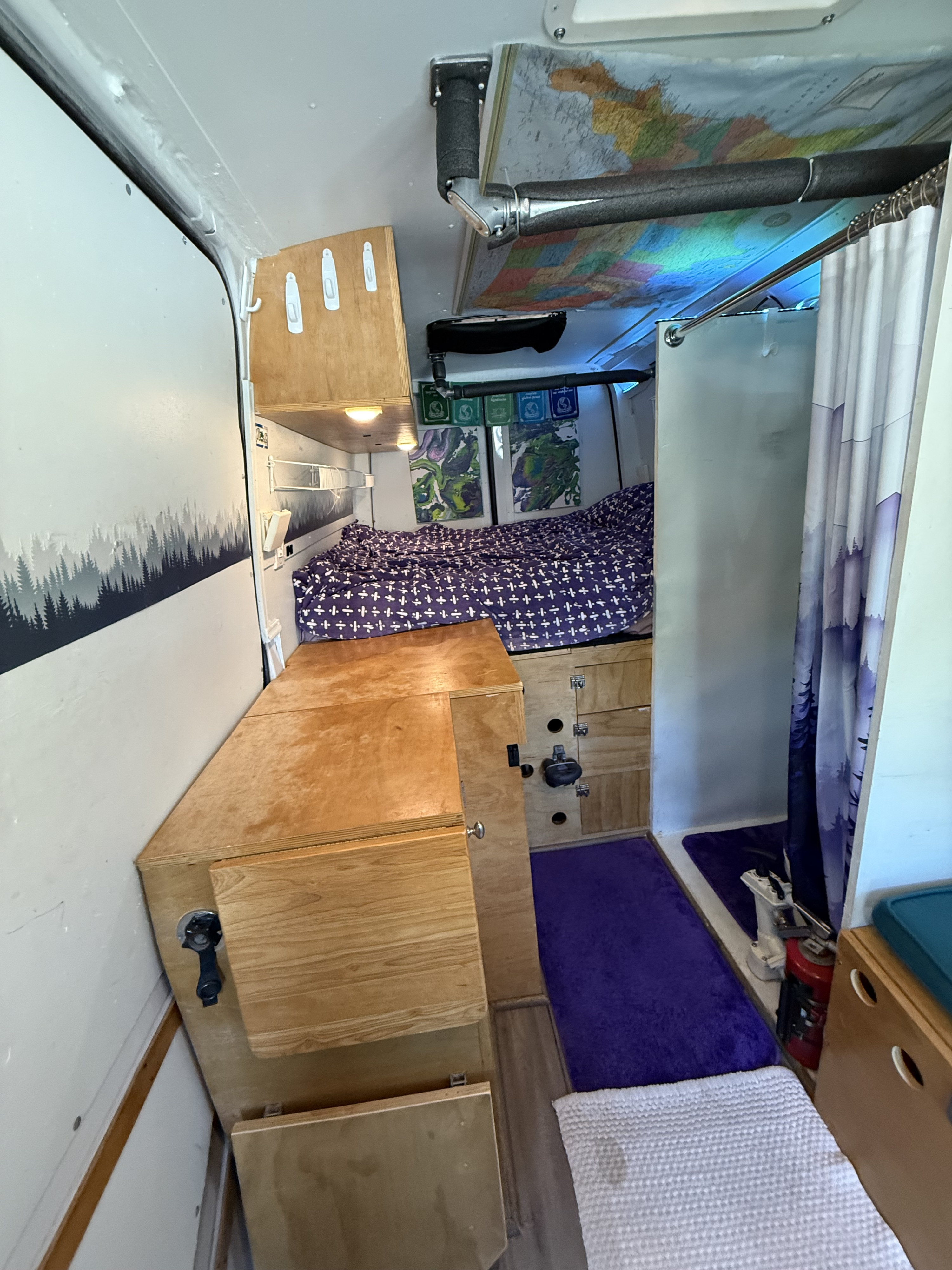 Explore this converted van RV rental interior: comfy bed, compact storage, and a unique map ceiling. Perfect for travel adventures.. Mercedes-Benz Sprinter RV Motorhome Campervan 2018