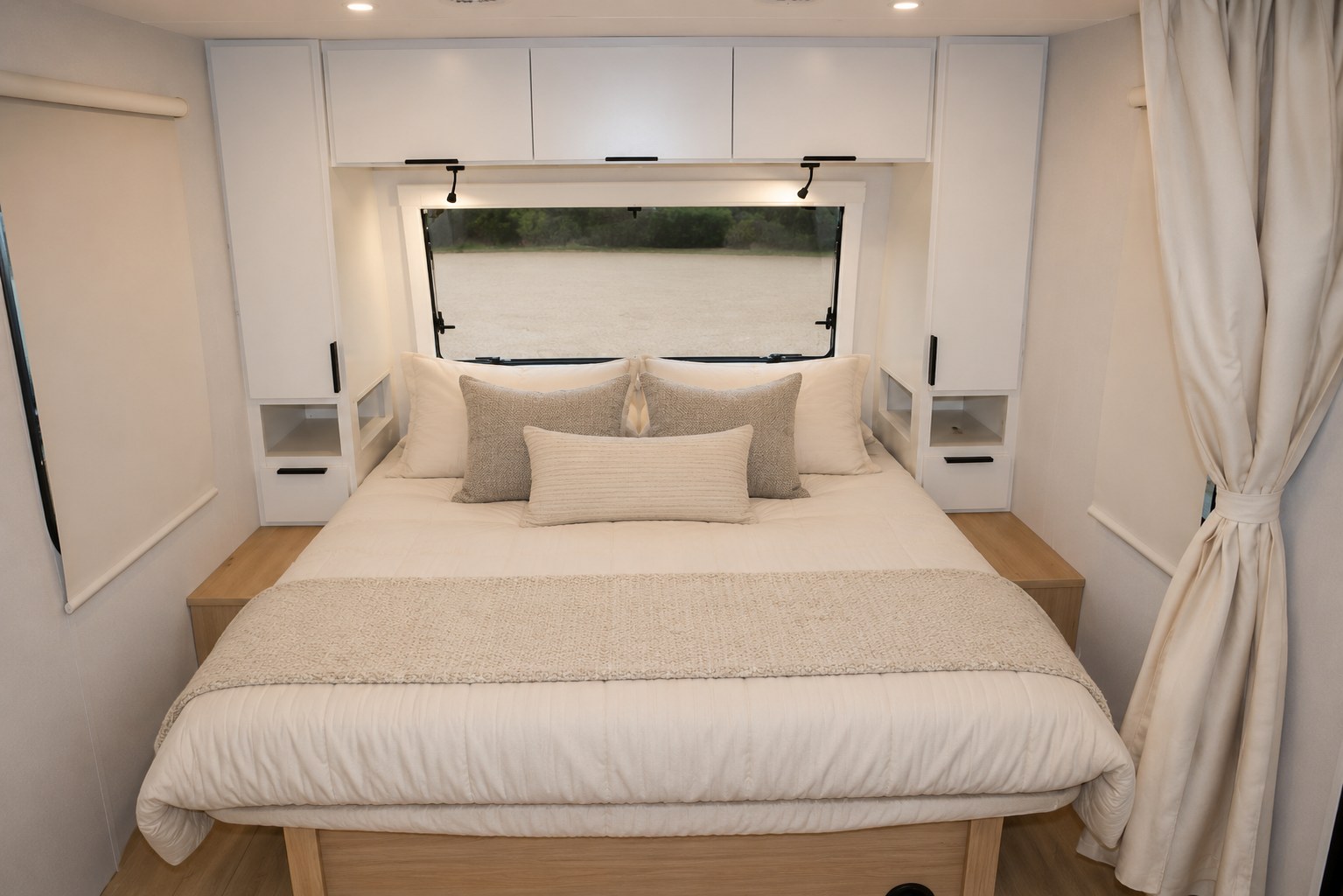 Cozy, modern RV rental bedroom features a comfortable bed, built-in storage, plush bedding, and a scenic window view for travel.. Winnebago Thrive 2026