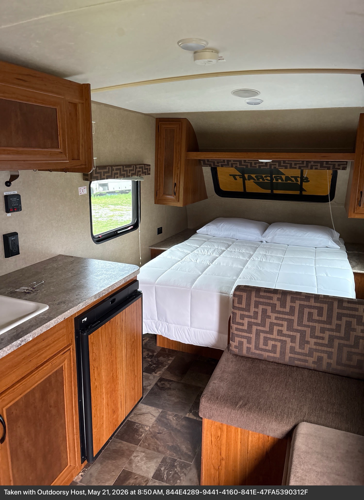 This rv rental offers a compact interior with a full bed, kitchen counter, fridge, and seating, all within reach for convenience.. Starcraft AR-One 2017
