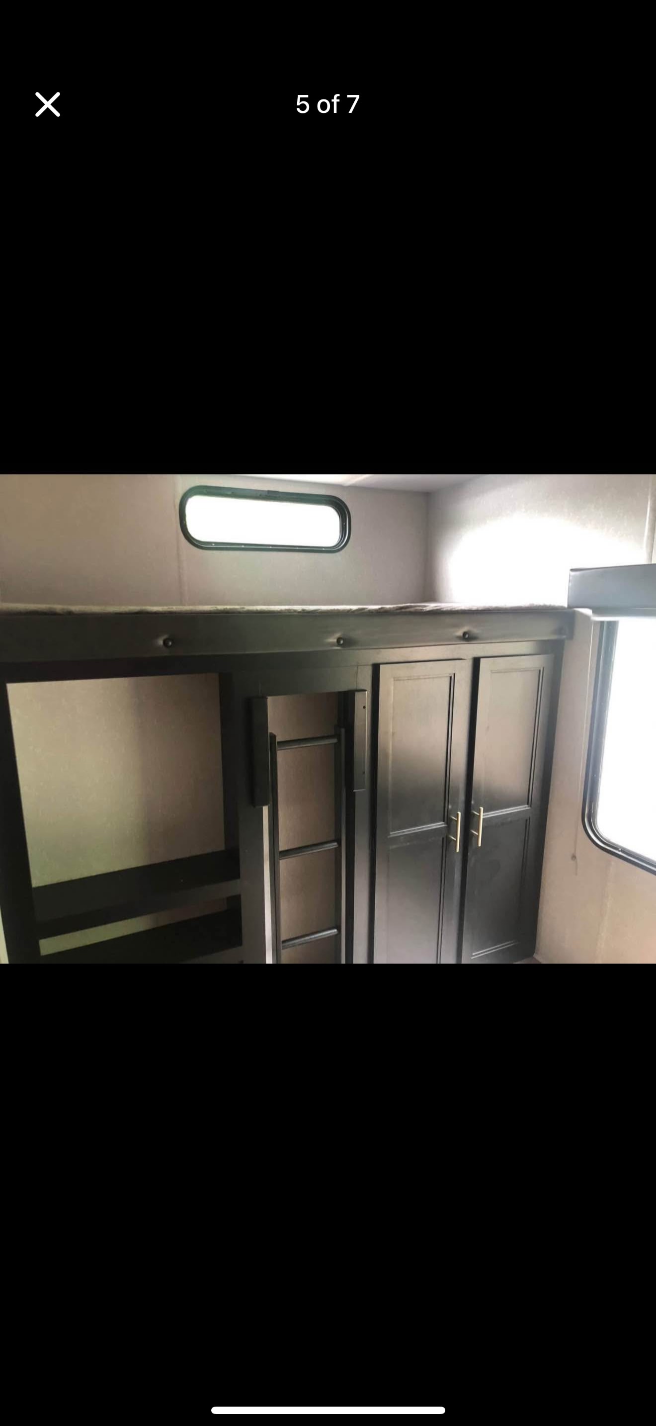 RV rental interior featuring bunk beds, a built-in wardrobe, and windows, ideal for compact travel comfort.. Forest River Cherokee 2022