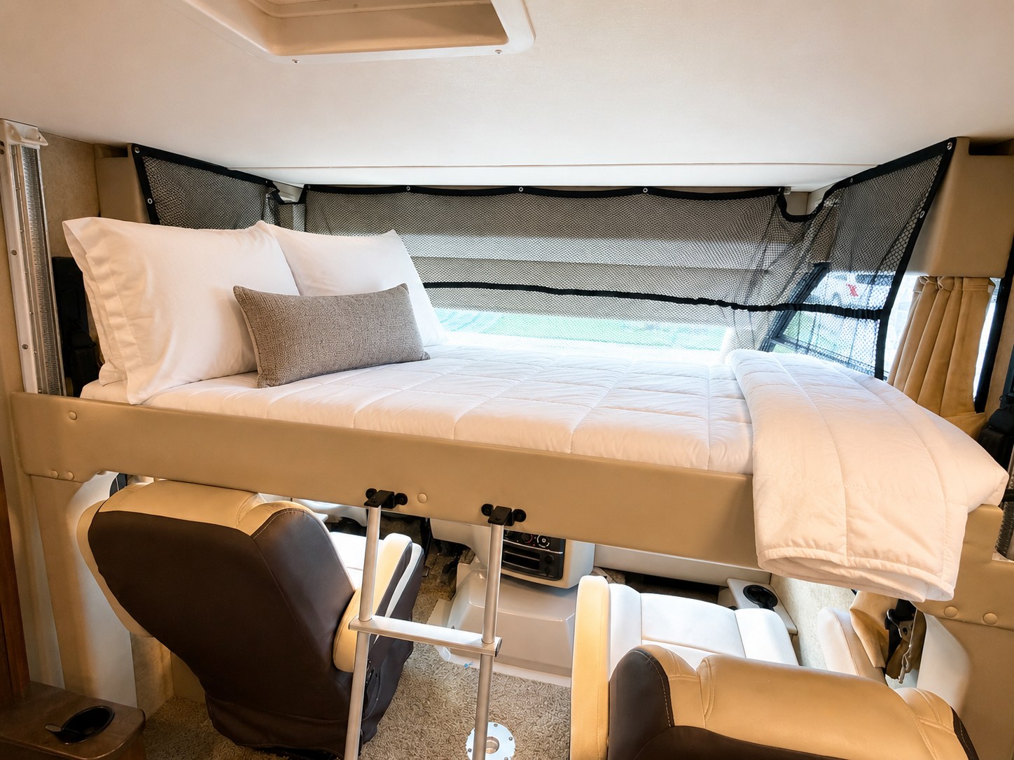 This RV rental features a cozy cab-over bunk bed with safety netting above swivel chairs, perfect for travel.. Thor Vegas 2016