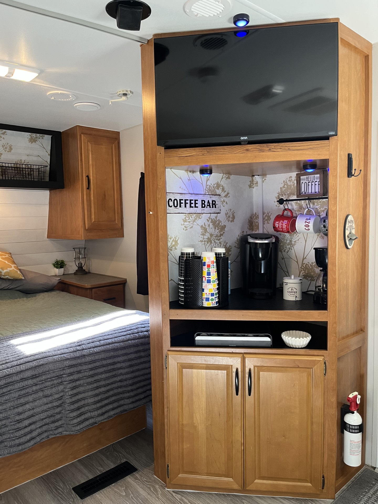 RV rental interior: cozy bedroom, built-in entertainment unit with TV, and a fully stocked coffee bar nook.. Wilderness Wilderness Trailer 2006