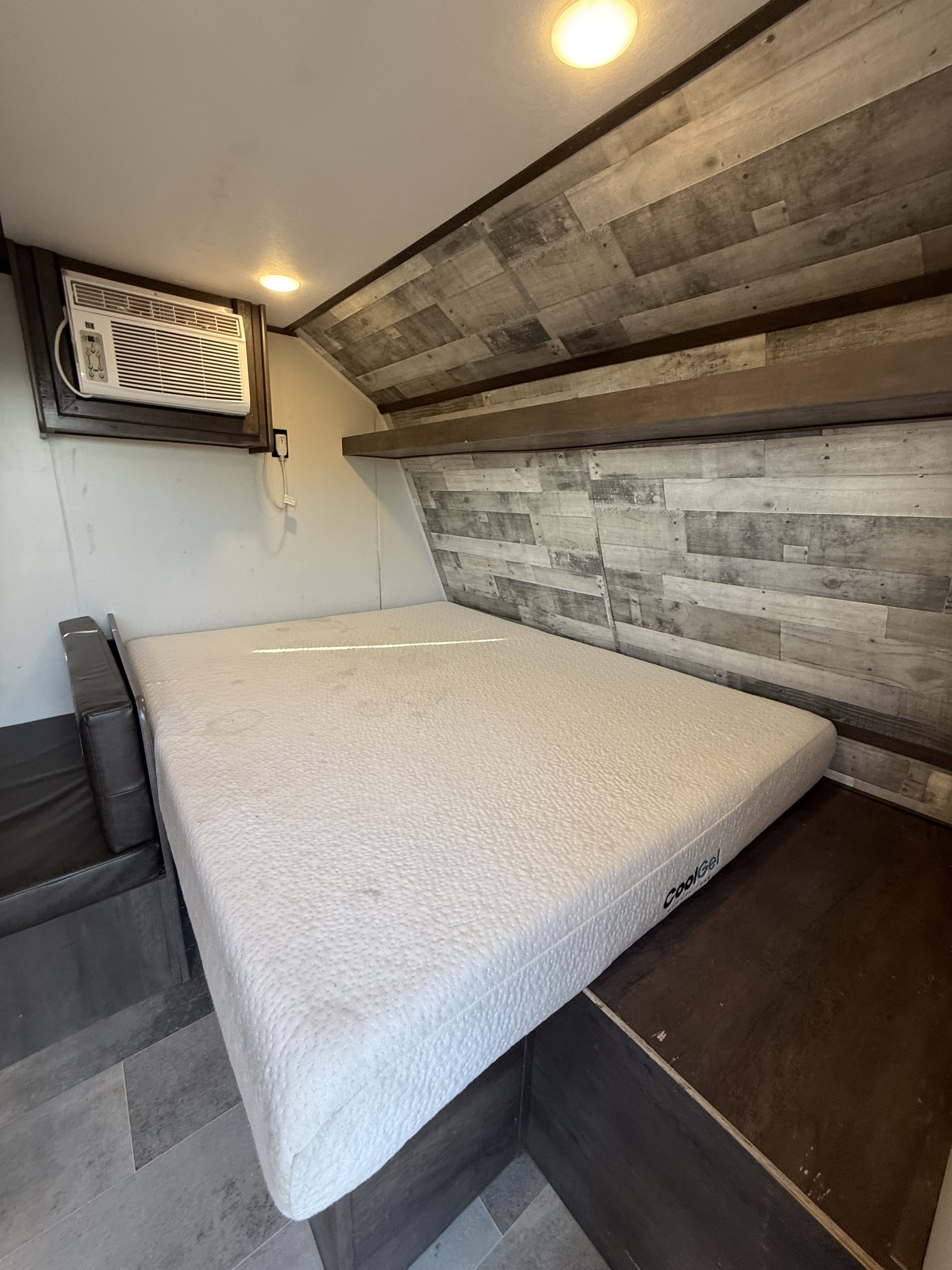 RV rental bedroom: Features a CoolGel mattress, wall AC, wood-paneled walls/ceiling, & recessed lights.. Coleman 17B Dutchmen 2022