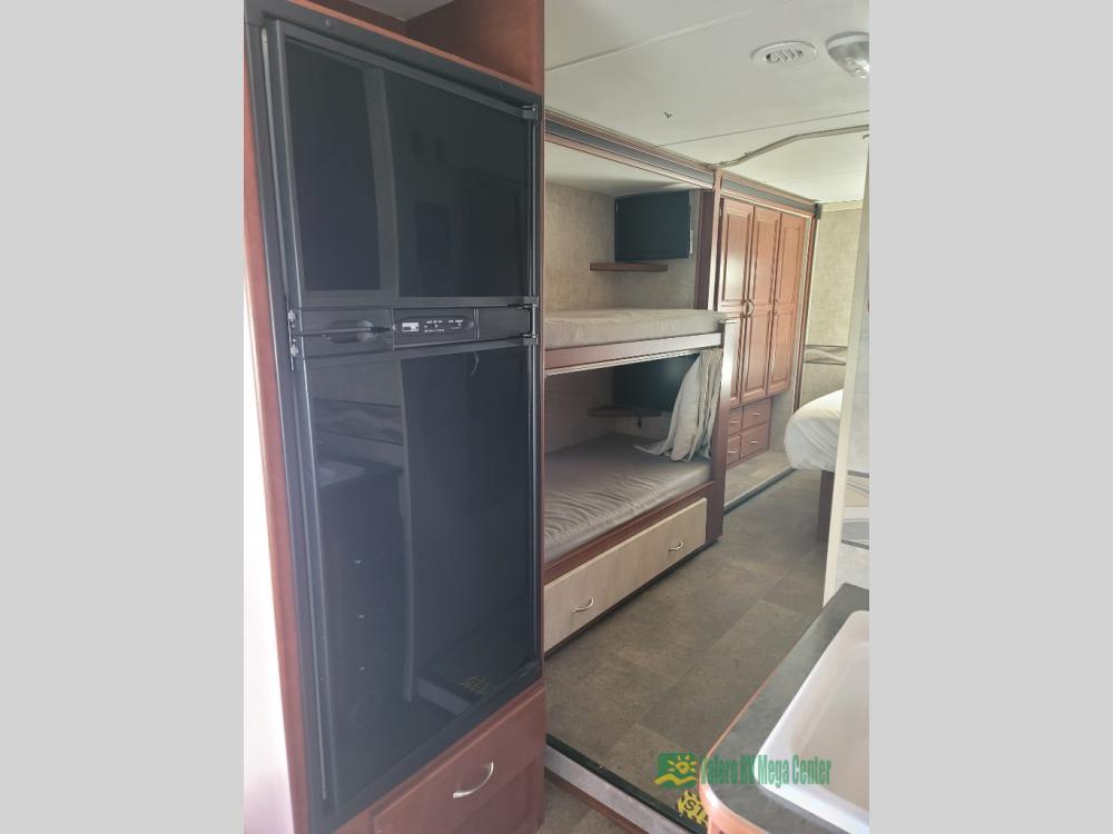 This RV rental interior offers bunk beds with TVs, a full-size refrigerator, and ample storage, perfect for family adventures.. Itasca Spirit 2014
