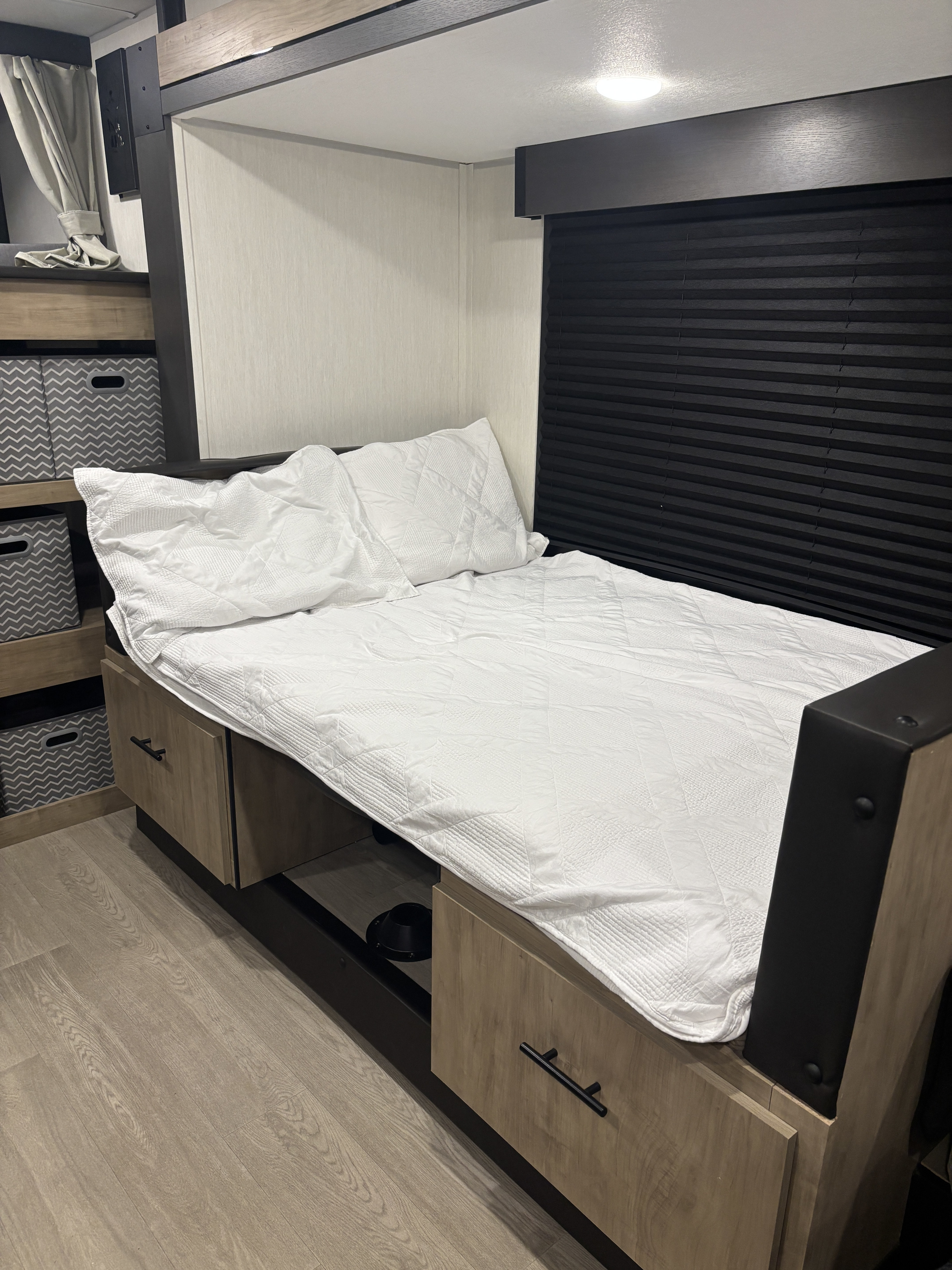 RV rental sleeping area: comfy bed, under-bed storage, bunk overhead, and dark blinds for restful nights.. Forest River Campsite Reserve 2026