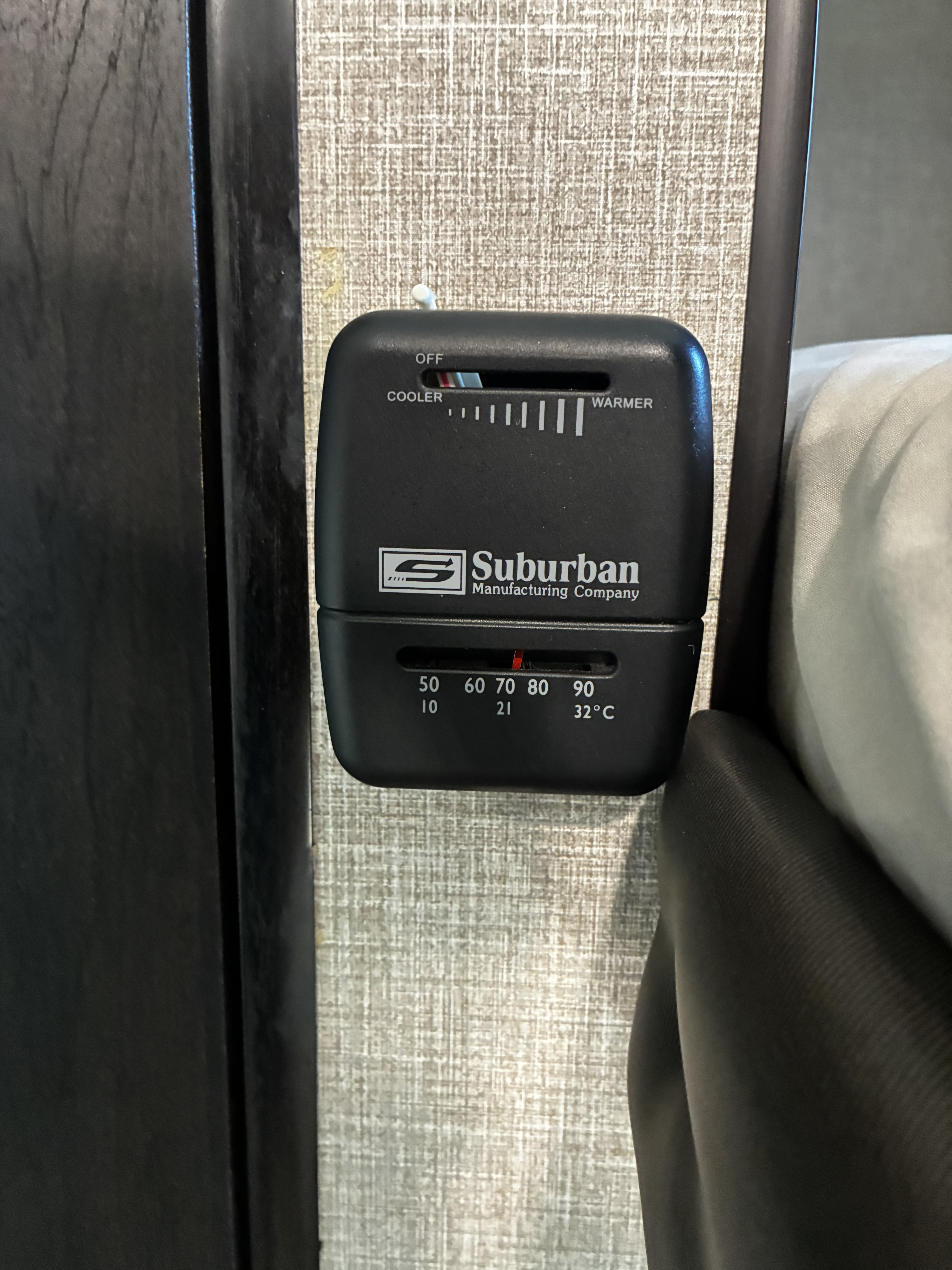 Black Suburban RV rental thermostat with temperature set to 70°F (21°C) for climate control.. Jayco Jay Flight SLX Baja Edition 2022