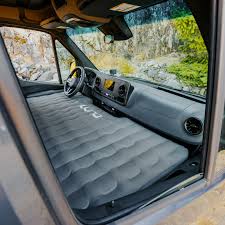 RV rental van with an inflatable mattress filling the front cab, creating a comfy sleeping area for camping and travel.. Winnebago Revel 2026