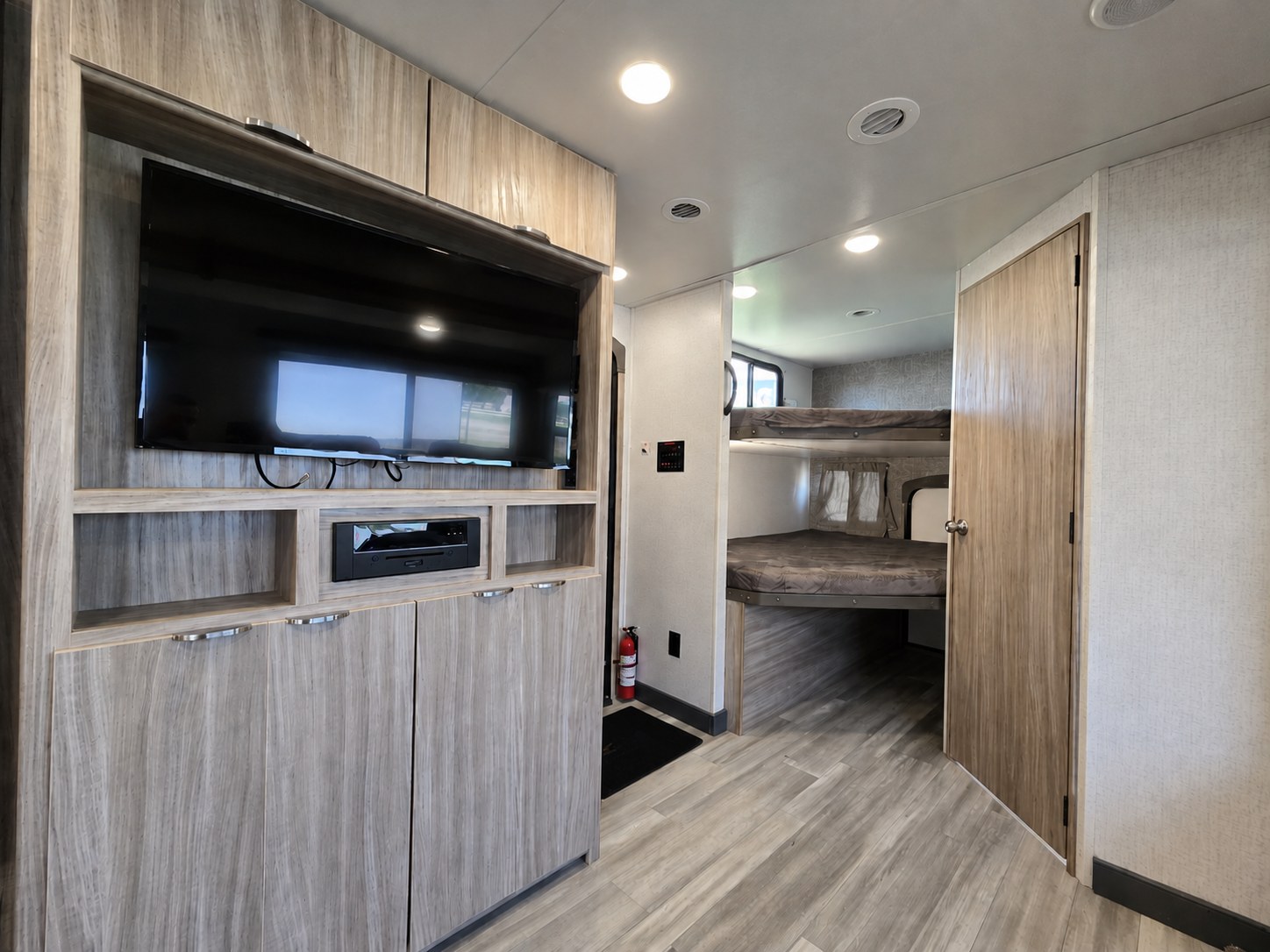 Modern RV rental interior featuring a TV, entertainment system, and cozy bunk beds for comfortable travel.. Minnie Minnie Trailer 2022