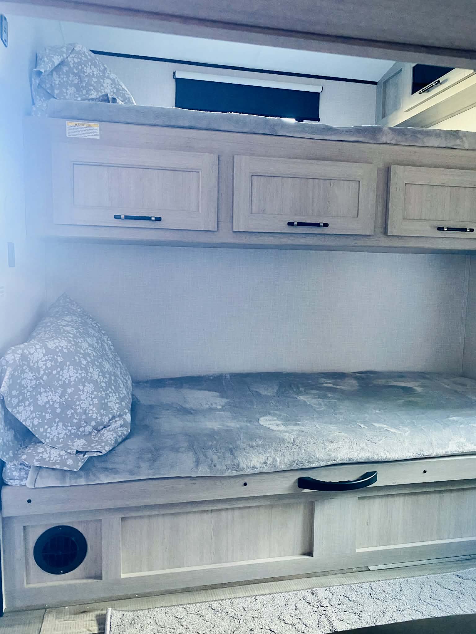 RV rental bunk beds feature two sleeping areas, overhead cabinets, and a lower drawer for storage. Light wood interior with cozy bedding.. Crossroads RV Sunset Trail Super Lite 2025