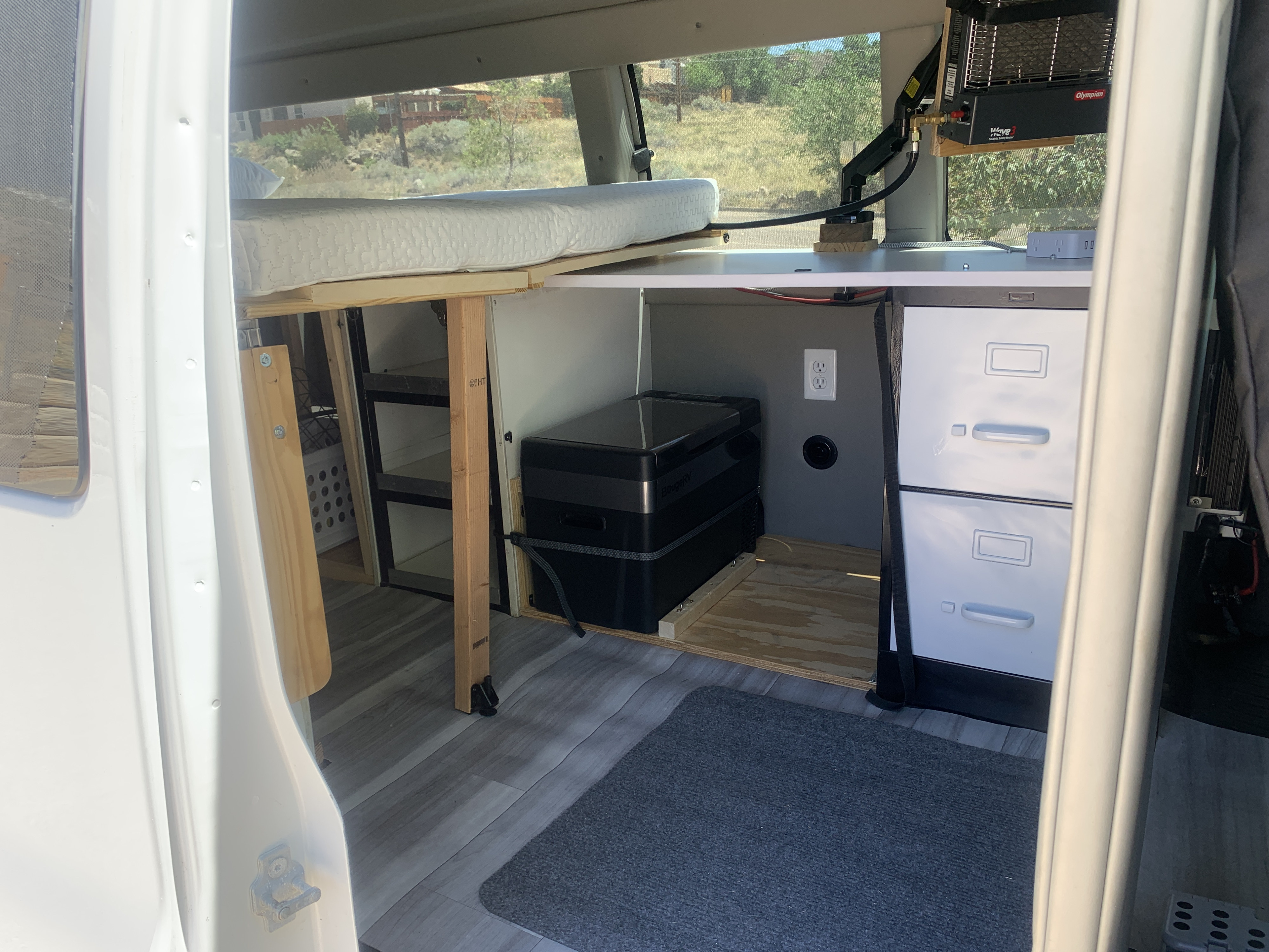 Van conversion for rv rental: Features a comfy bed, portable fridge, catalytic heater, and storage, ready for adventure.. Chevrolet Express 2011