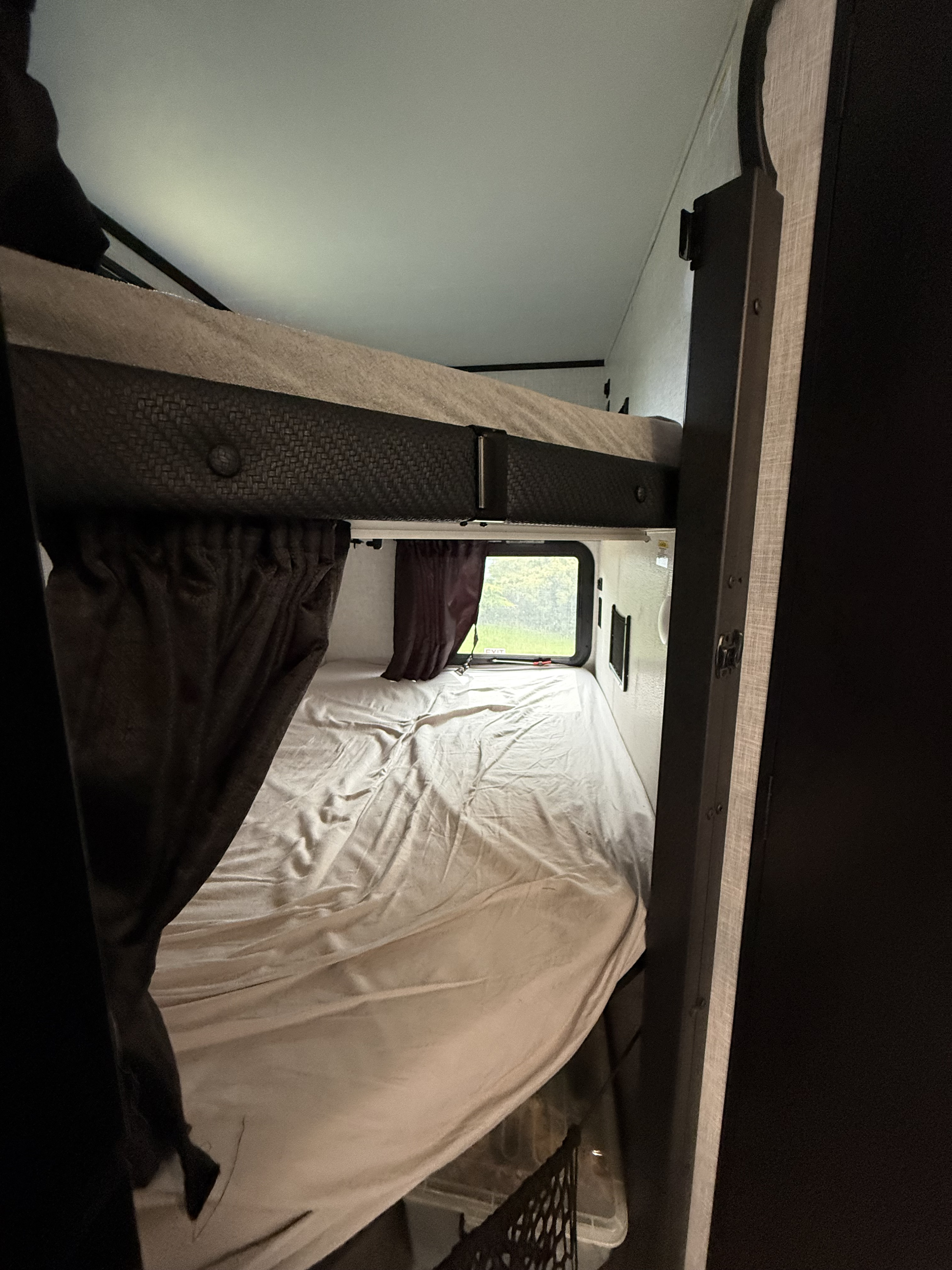 Cozy RV rental sleeping area with bunk beds and a window for scenic views, perfect for travel trailer road trips.. Jayco Jay Feather Micro 2025