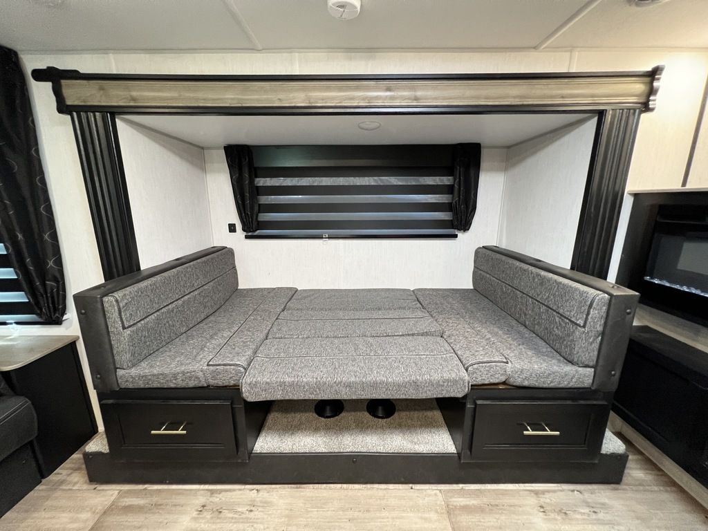 Explore this RV rental's versatile interior: a modern gray dinette converts to a cozy bed, complete with under-seat storage.. Forest River Cherokee Grey Wolf 2022