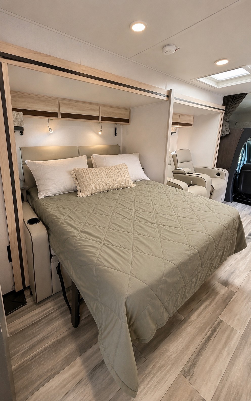 Relax in this comfortable RV rental bedroom, featuring a large bed, overhead storage, reading lights, and plush recliners.. Forest River Sunseeker MBS 2022