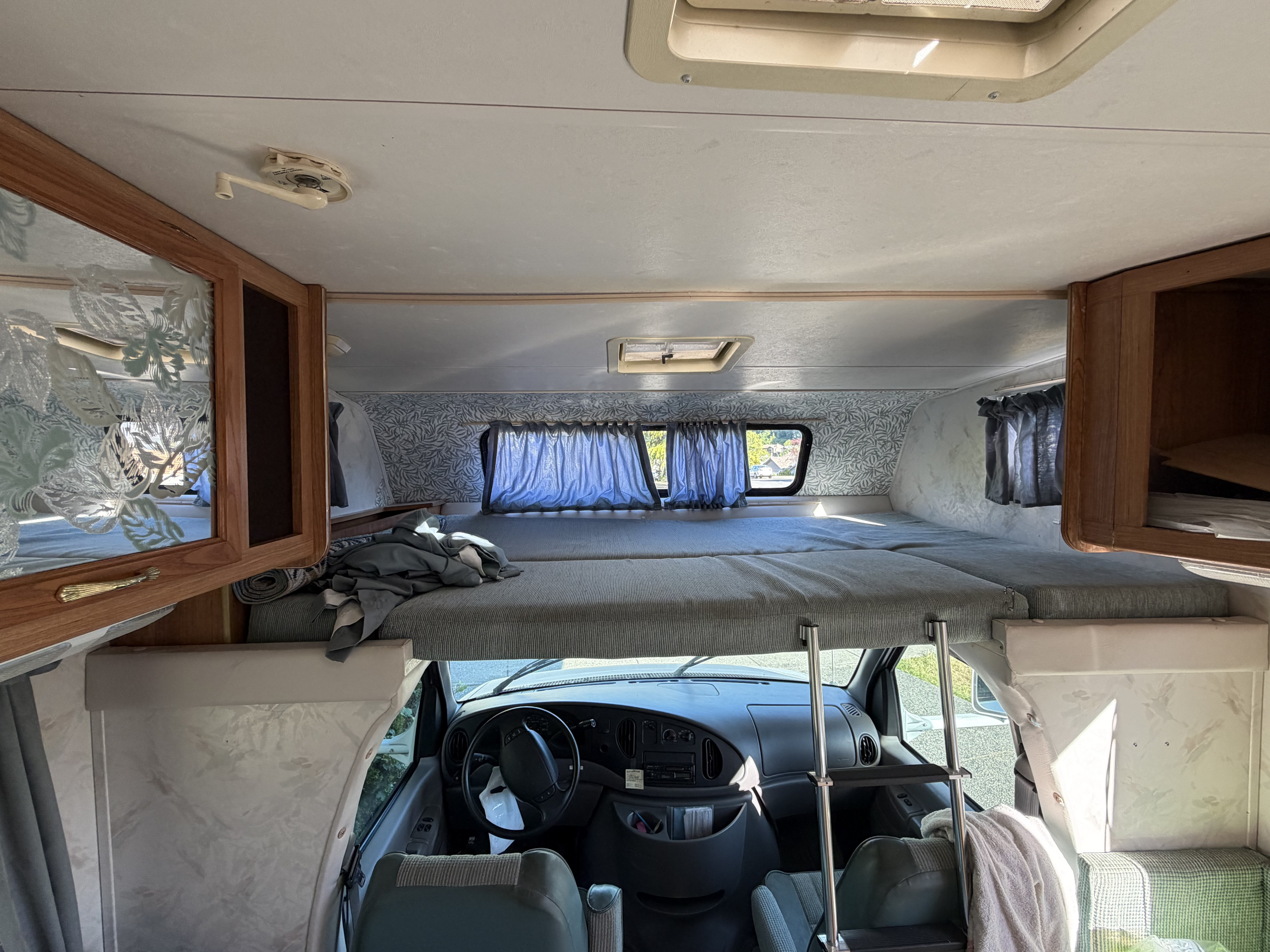 Spacious RV rental interior with a cozy cab-over bed, front cabin view, and ample storage for your road trip adventures.. Ford Rv E-350/Catalina 1997