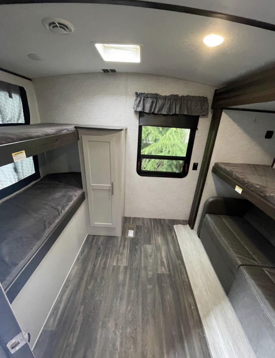 Family-friendly RV rental with spacious bunk beds, cozy interior, and natural light, perfect for group travel.. Keystone RV Bullet Premier Ultra 2021