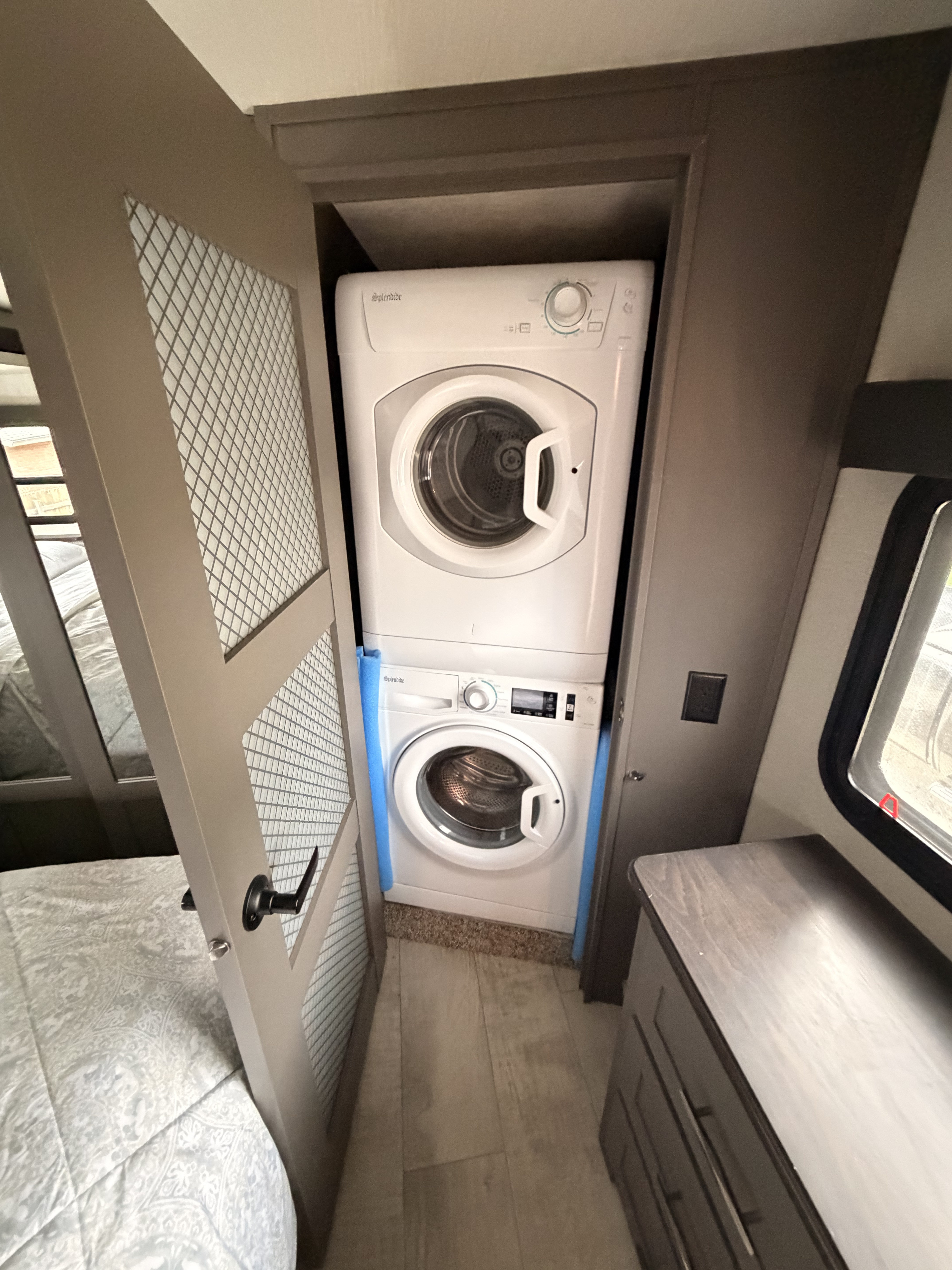 This rv rental offers a compact Splendide washer & dryer combo, conveniently stacked in a closet next to a bed.. Grand Design Momentum Toy Hauler 2021