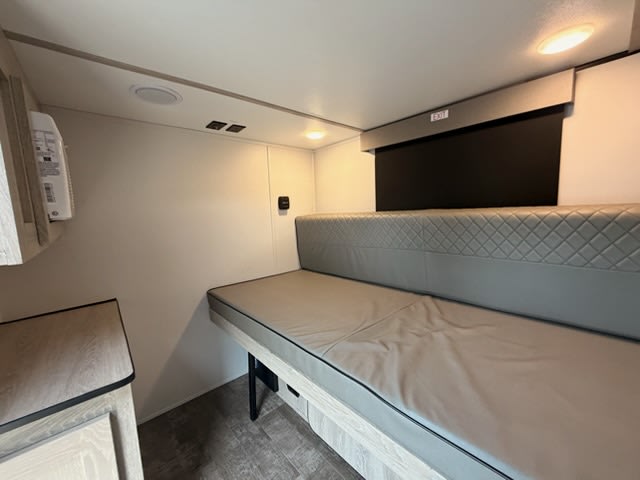 This modern RV rental interior features a versatile bench bed, overhead lighting, and compact storage, ideal for travel.. Riverside 511 2025