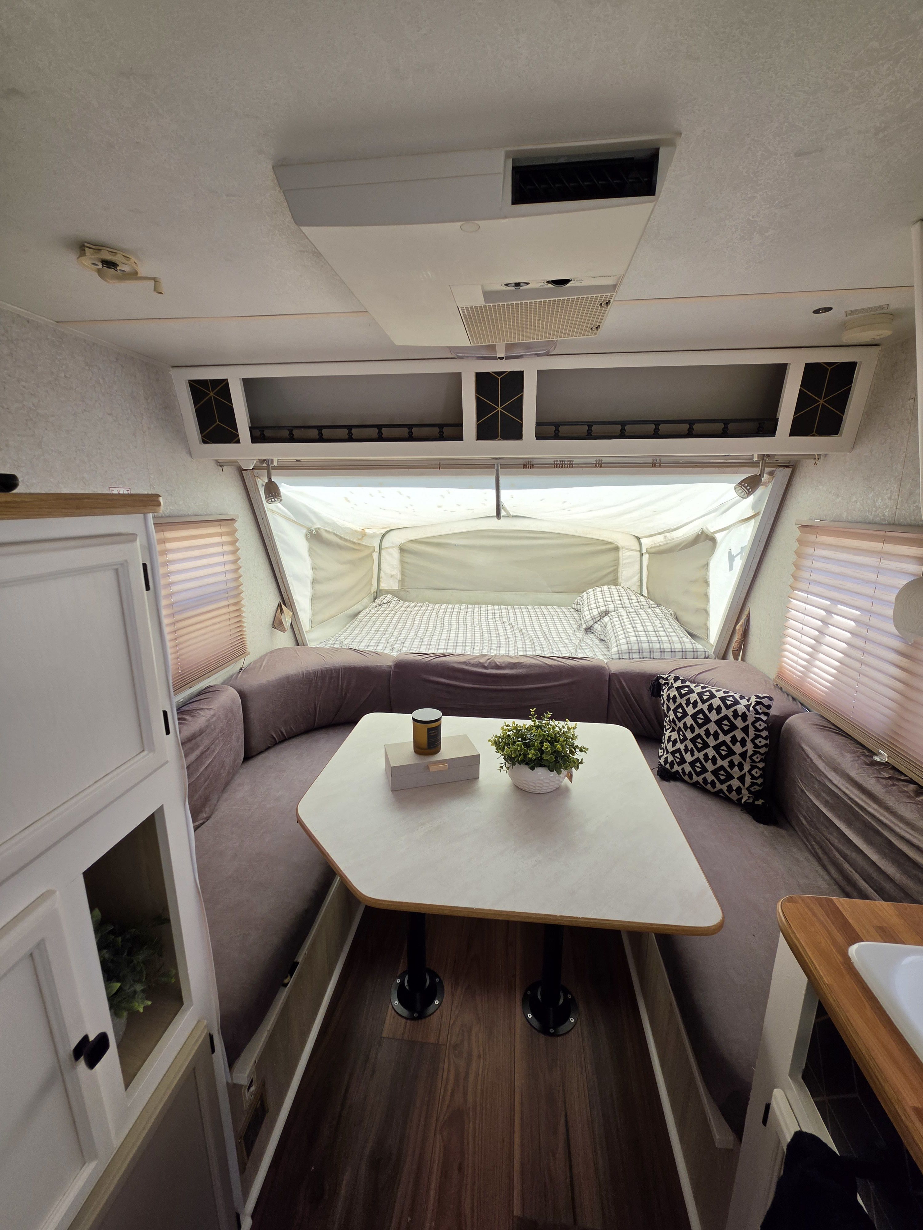 This rv rental features a cozy interior with a U-shaped dining area, pop-out bed, and smart overhead storage.. R-Vision Trail-Lite Bantam 2002
