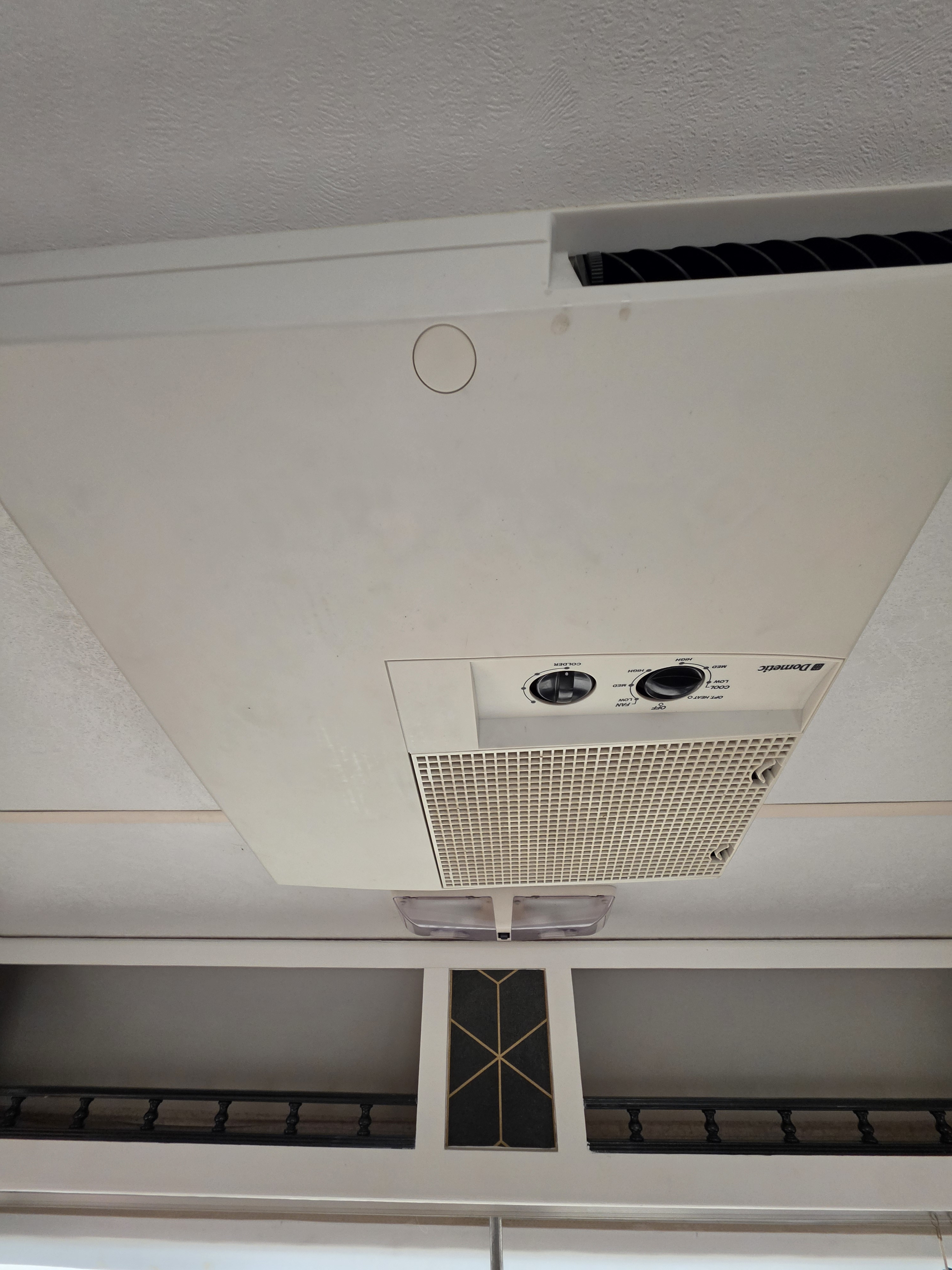 Overhead Dometic RV air conditioner with fan/temp controls and intake vent visible on the ceiling of an rv rental.. R-Vision Trail-Lite Bantam 2002