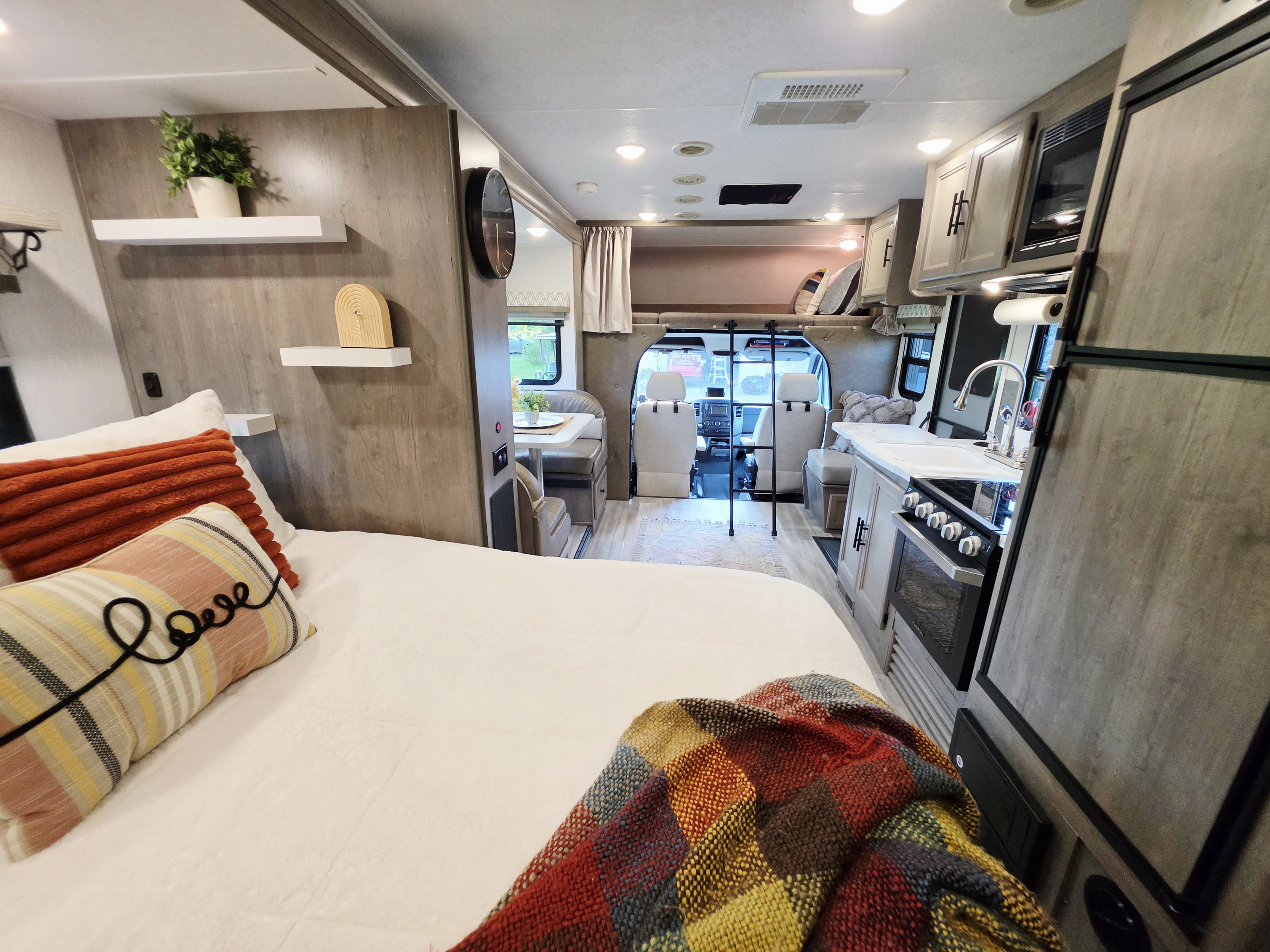 Spacious & cozy RV rental interior, featuring a comfortable bed, modern kitchen, and dinette, perfect for your next adventure.. Coachmen Prism 2018