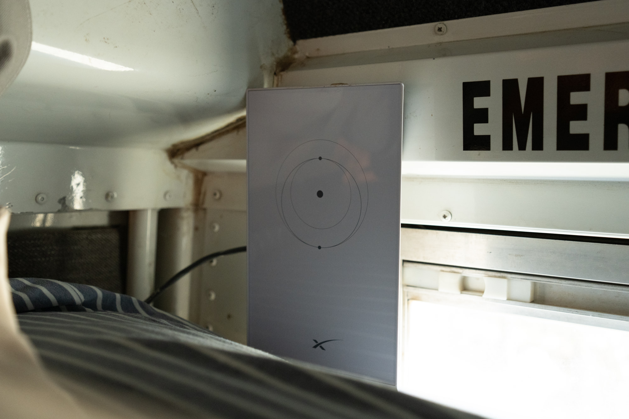 Starlink router for high-speed internet in an RV rental, nestled near a striped bunk and "EMER" sign.. Chevrolet Express s3500 2003