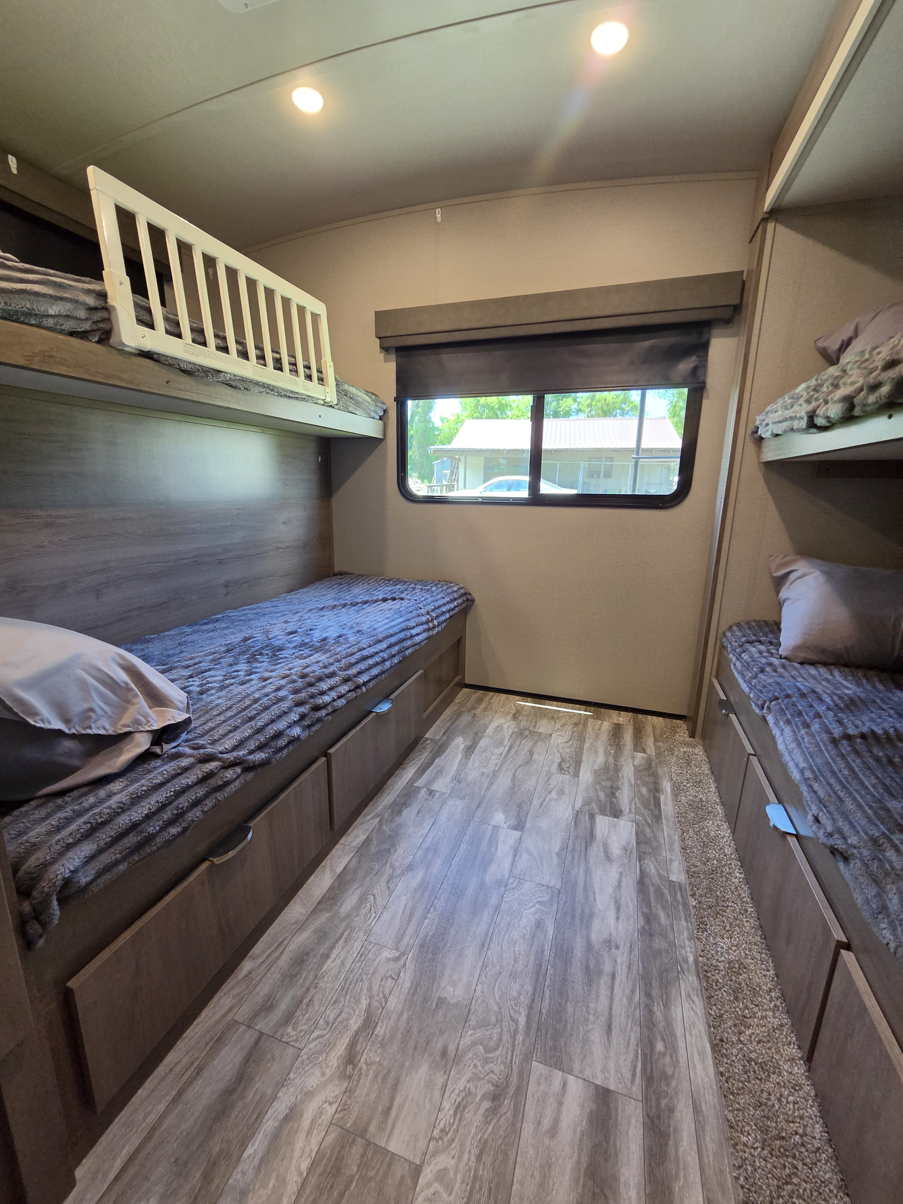 RV rental bunk room: comfy beds with storage drawers, safety rail, and a window for natural light.. Grand Design Imagine 2021