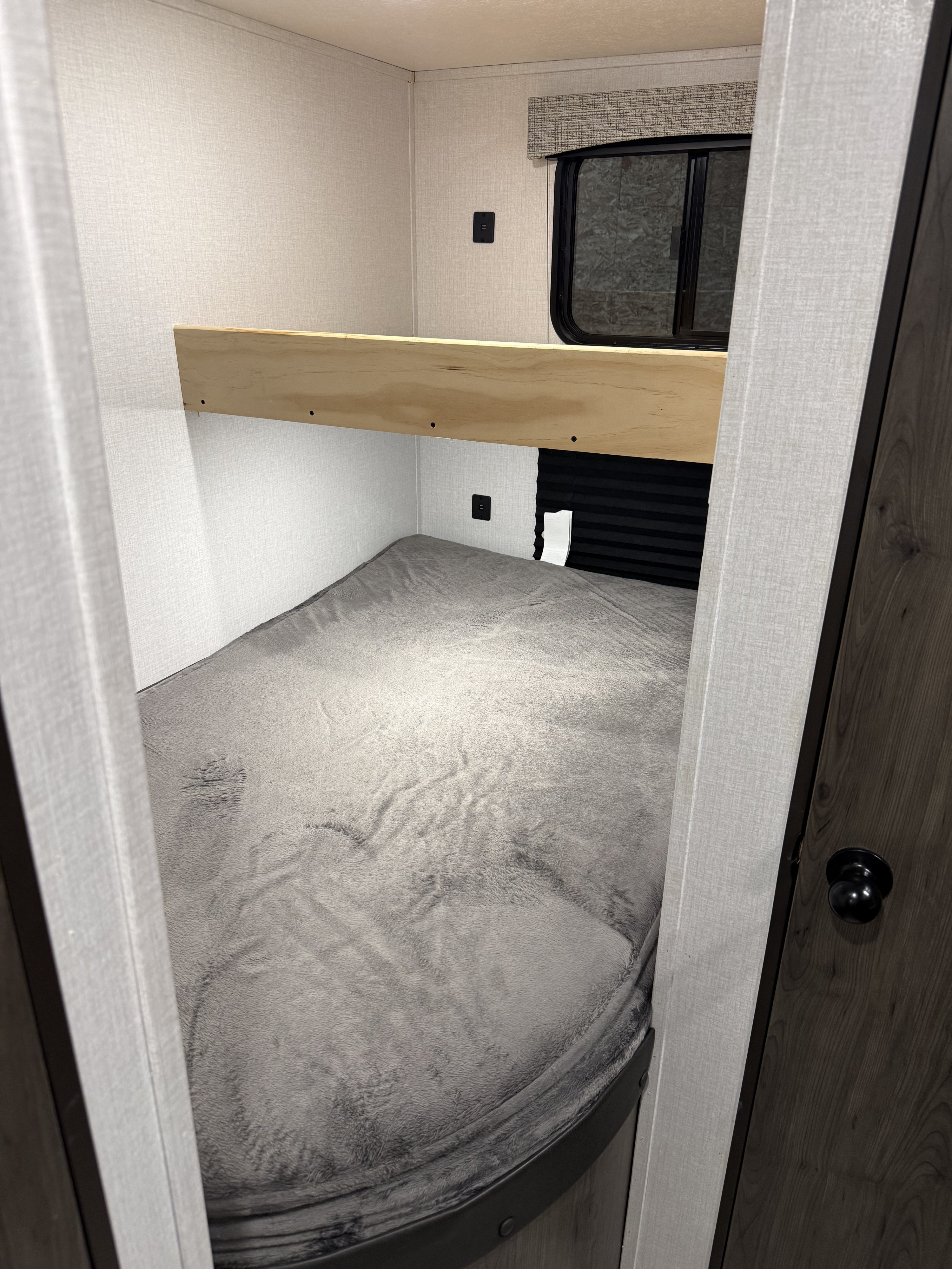 Cozy RV rental bunk bed area with a soft grey mattress, window with blinds, and USB charger for convenient sleeping.. Clipper Ultra Lite 2022