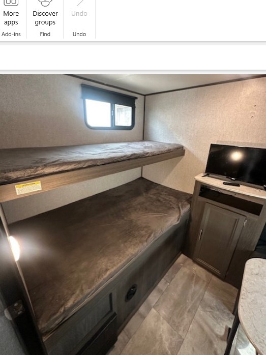 Cozy rv rental bunk bed area with two mattresses, a window, and a TV on a cabinet. Perfect for compact sleeping.. Dutchmen Kodiak SE 2021