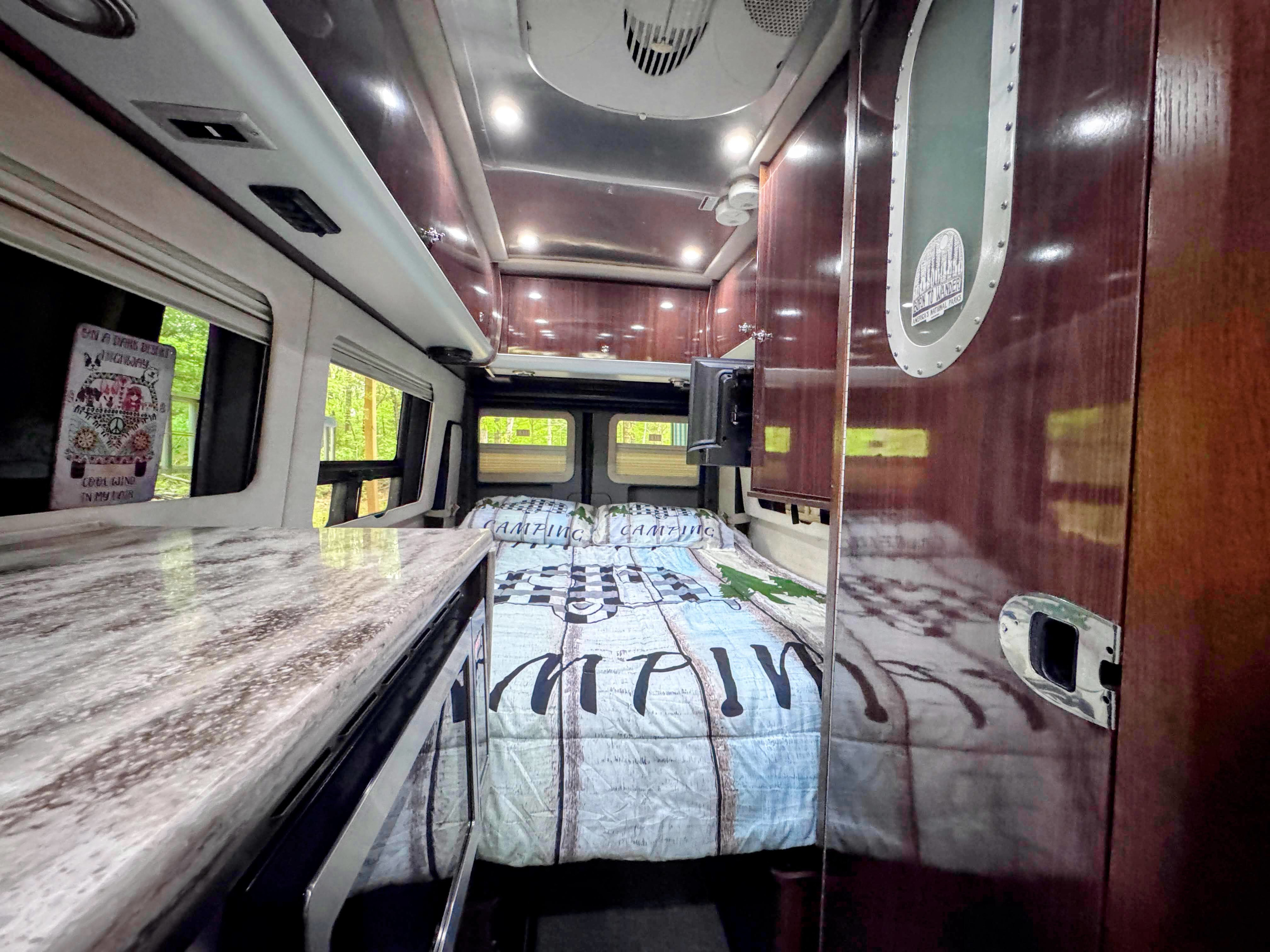 Explore in comfort! This RV rental features a cozy bed, kitchen counter, and scenic windows for your next camping trip.. Airstream Interstate 2016
