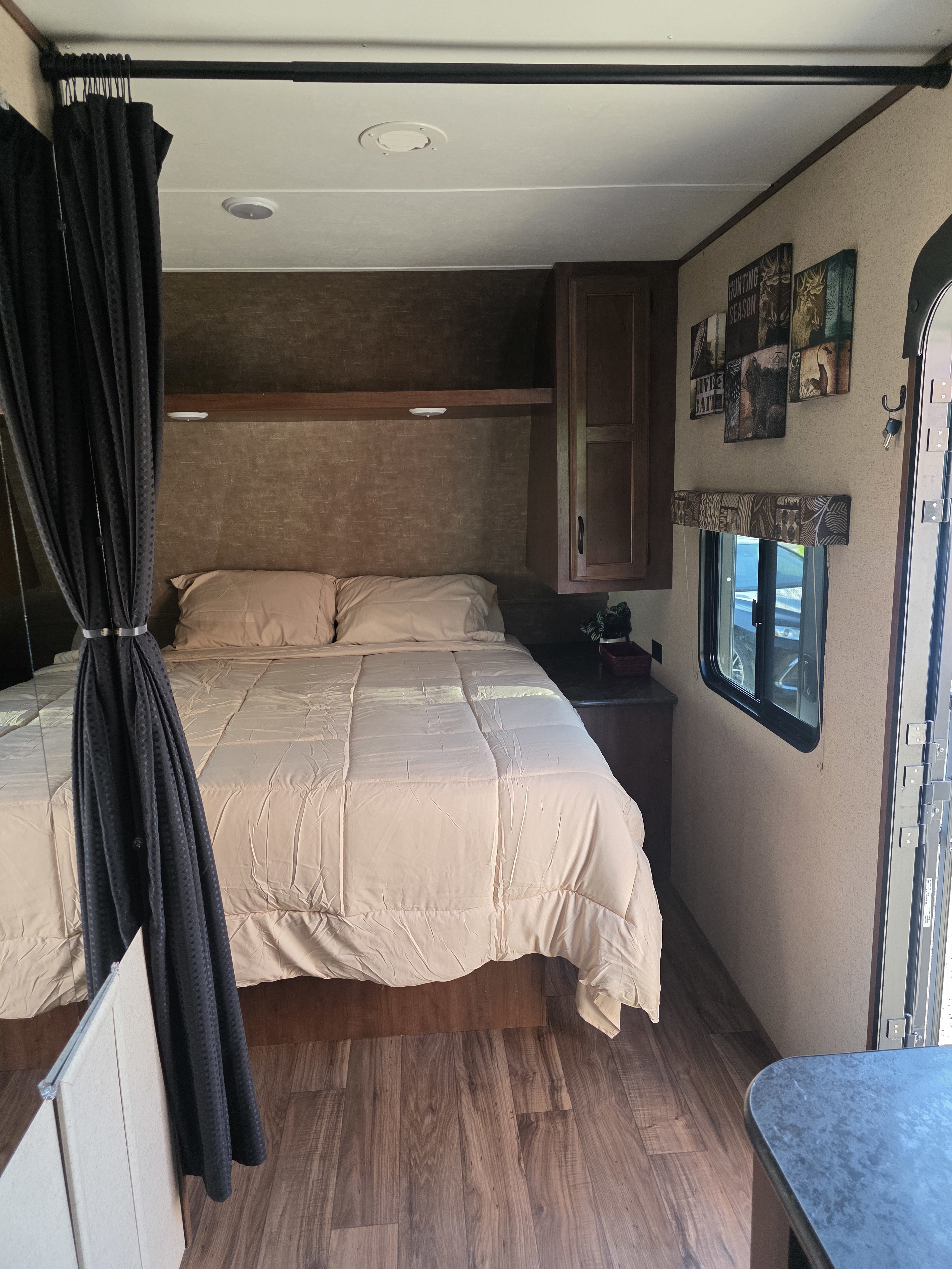Cozy RV rental bedroom interior with a neatly made bed, dark privacy curtains, and wood-look flooring.. Jayco Jay Flight SLX 2016