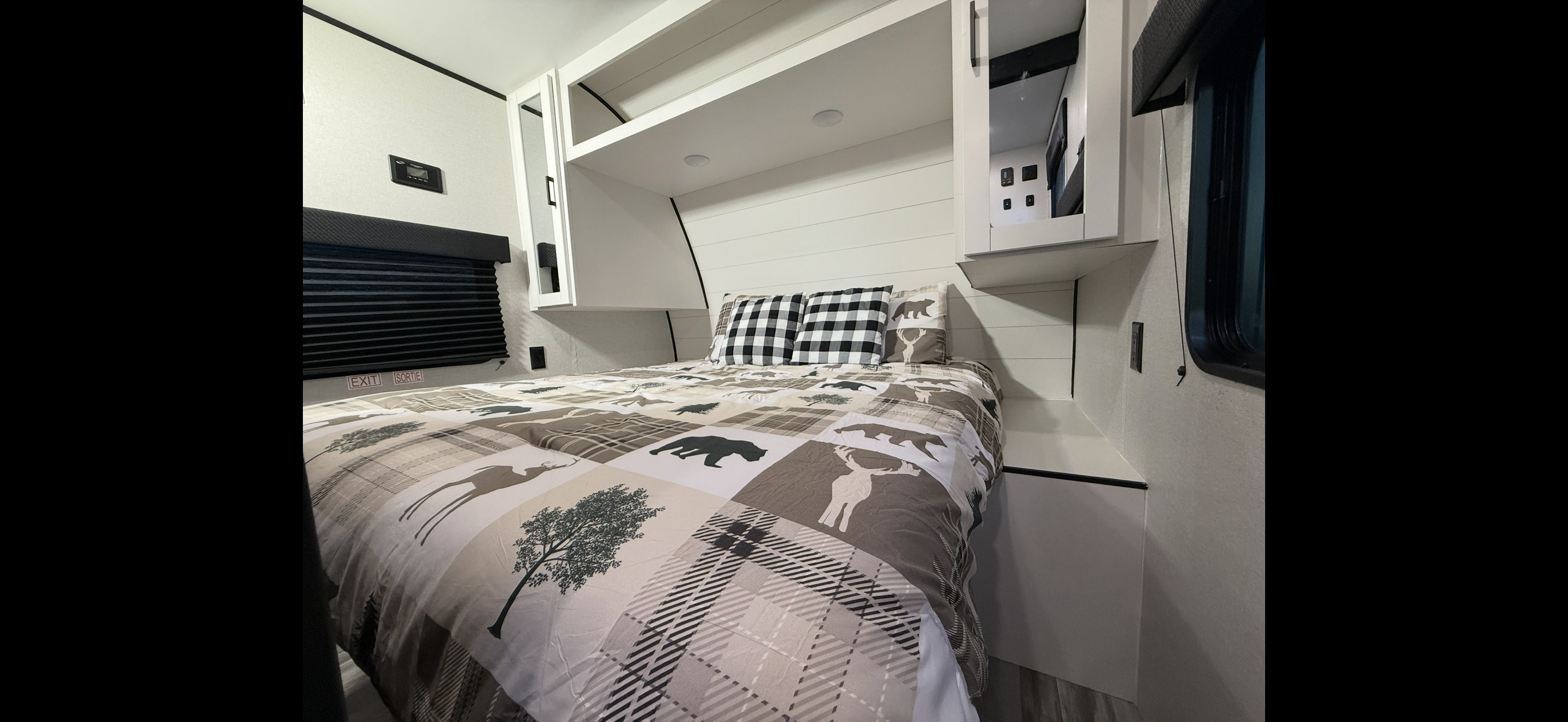 Relax in this RV rental bedroom! Features cozy nature-themed bedding, plaid pillows, overhead cabinets, and built-in storage.. Jayco Jay Flight SLX 261BHS 2026