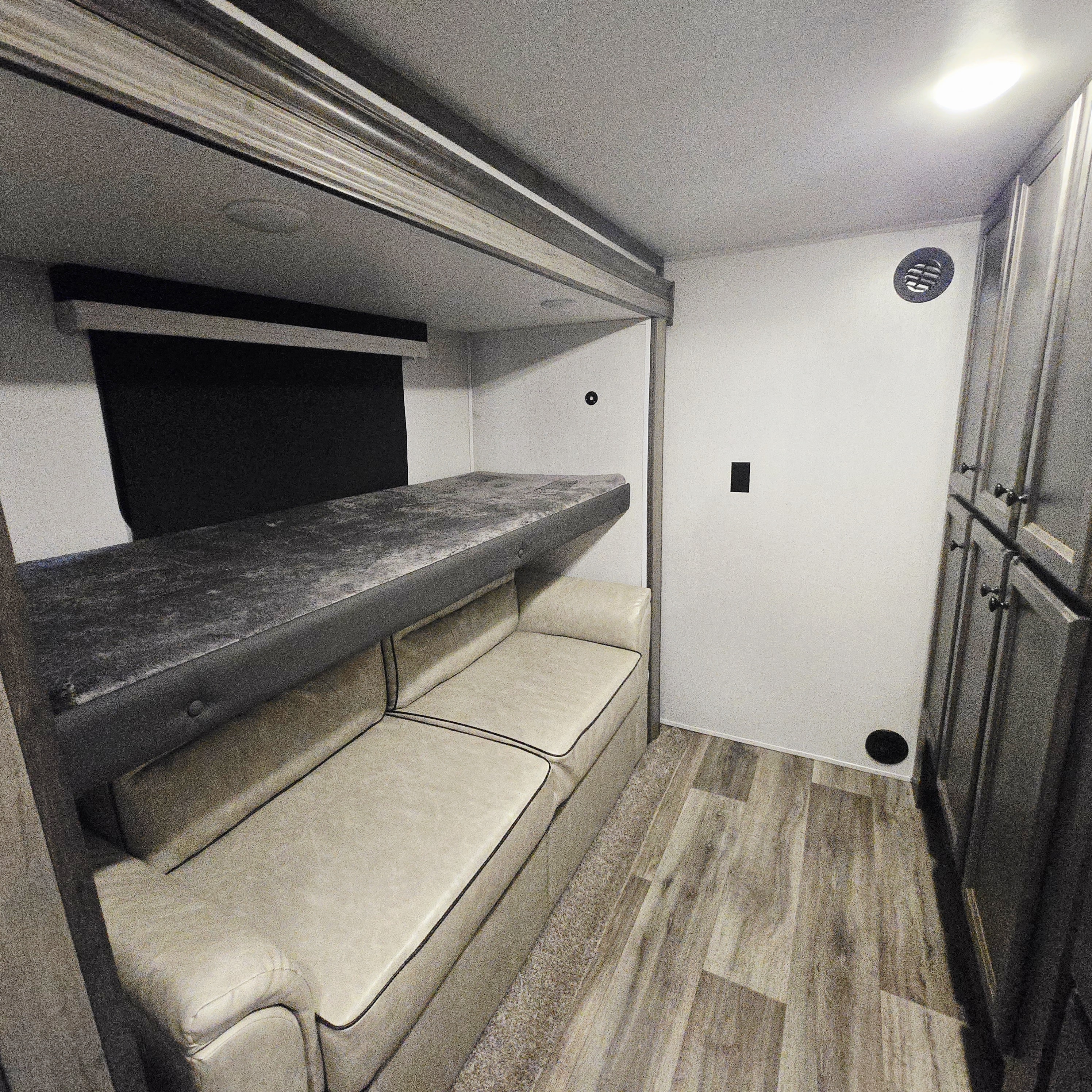 Inside this RV rental: a cozy bunk bed above a sofa, ample storage, and stylish wood-look flooring.. Forest River Cardinal Limited 2021